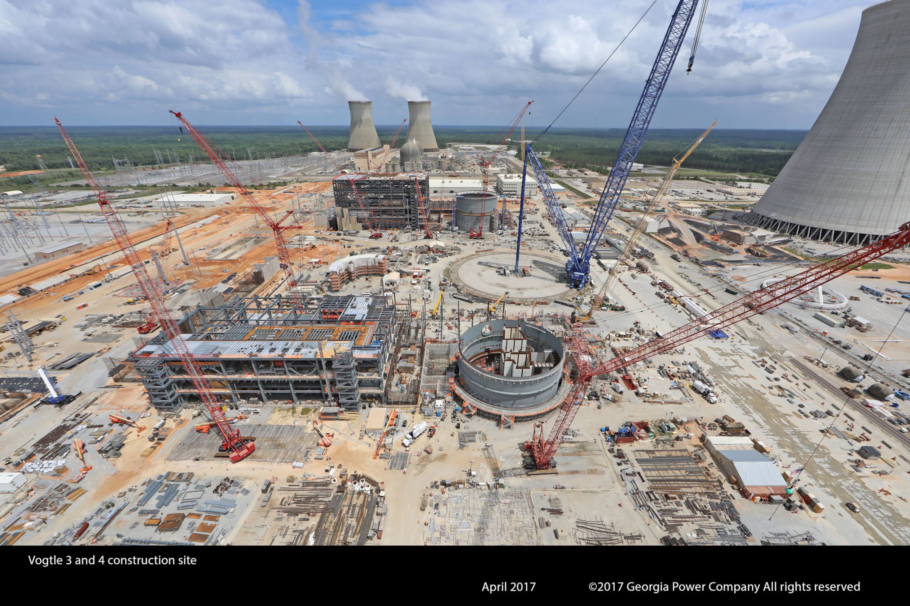 Steam rises from Plant Vogtle’s cooling towers for units 1 and 2, built in the 1970s and 1980s, while delays and cost overruns hamper construction of units 3 and 4. GEORGIA POWER