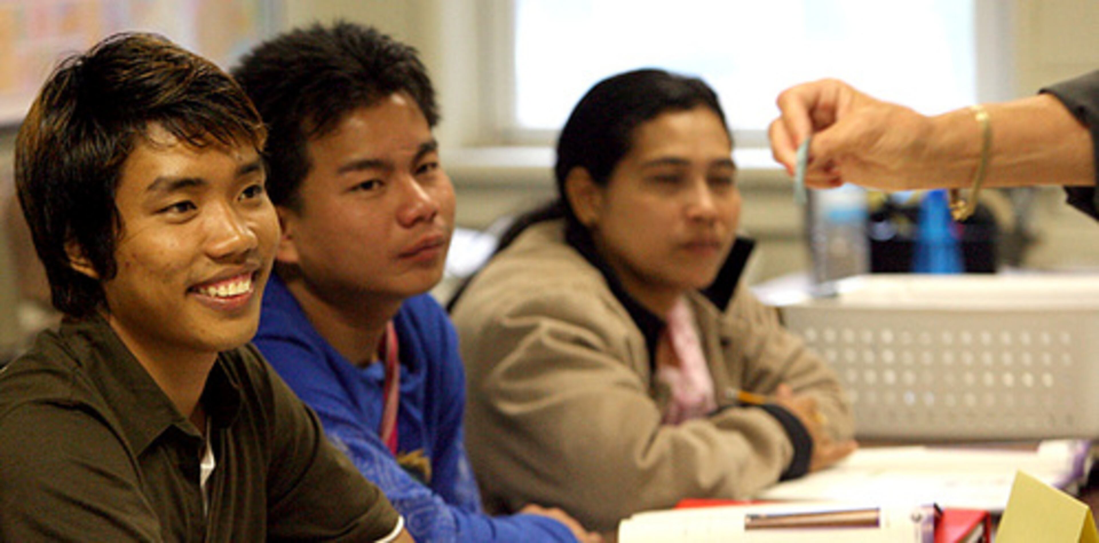 Aung Lwin Nge Ni (left) reads a number from a flash card while in English class with fellow Burmese refugees in Clarkston.