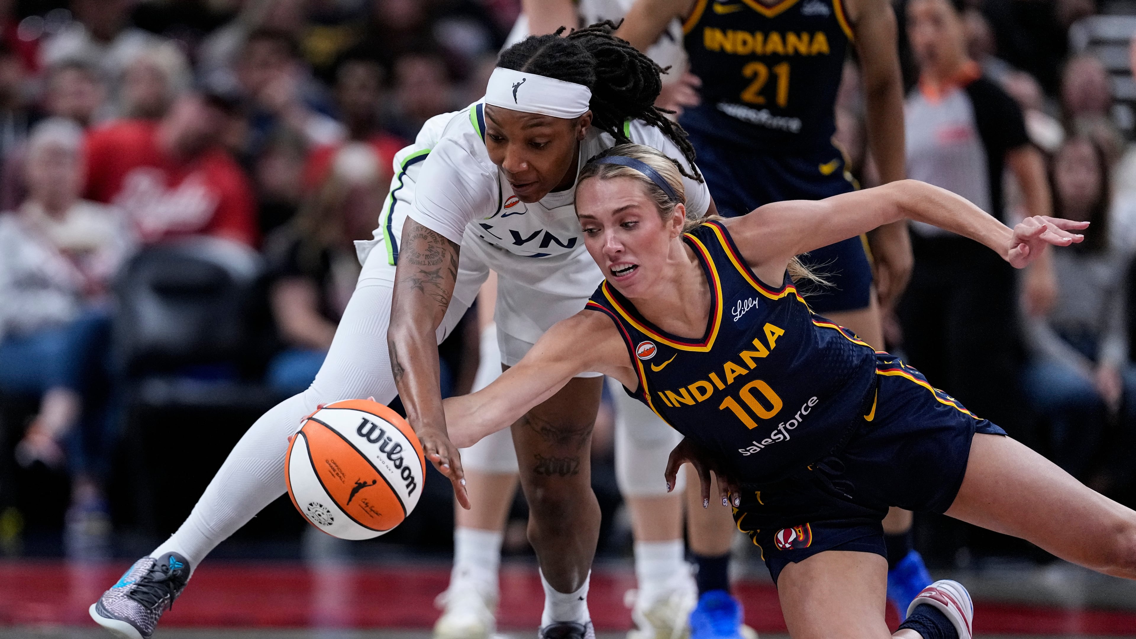 Indiana Fever guard Lexie Hull (10) and Minnesota Lynx forward Liatu King go for a loose ball in the first half of a WNBA basketball game in Indianapolis, Tuesday, Sept. 22, 2026. (AP Photo/Michael Conroy)
