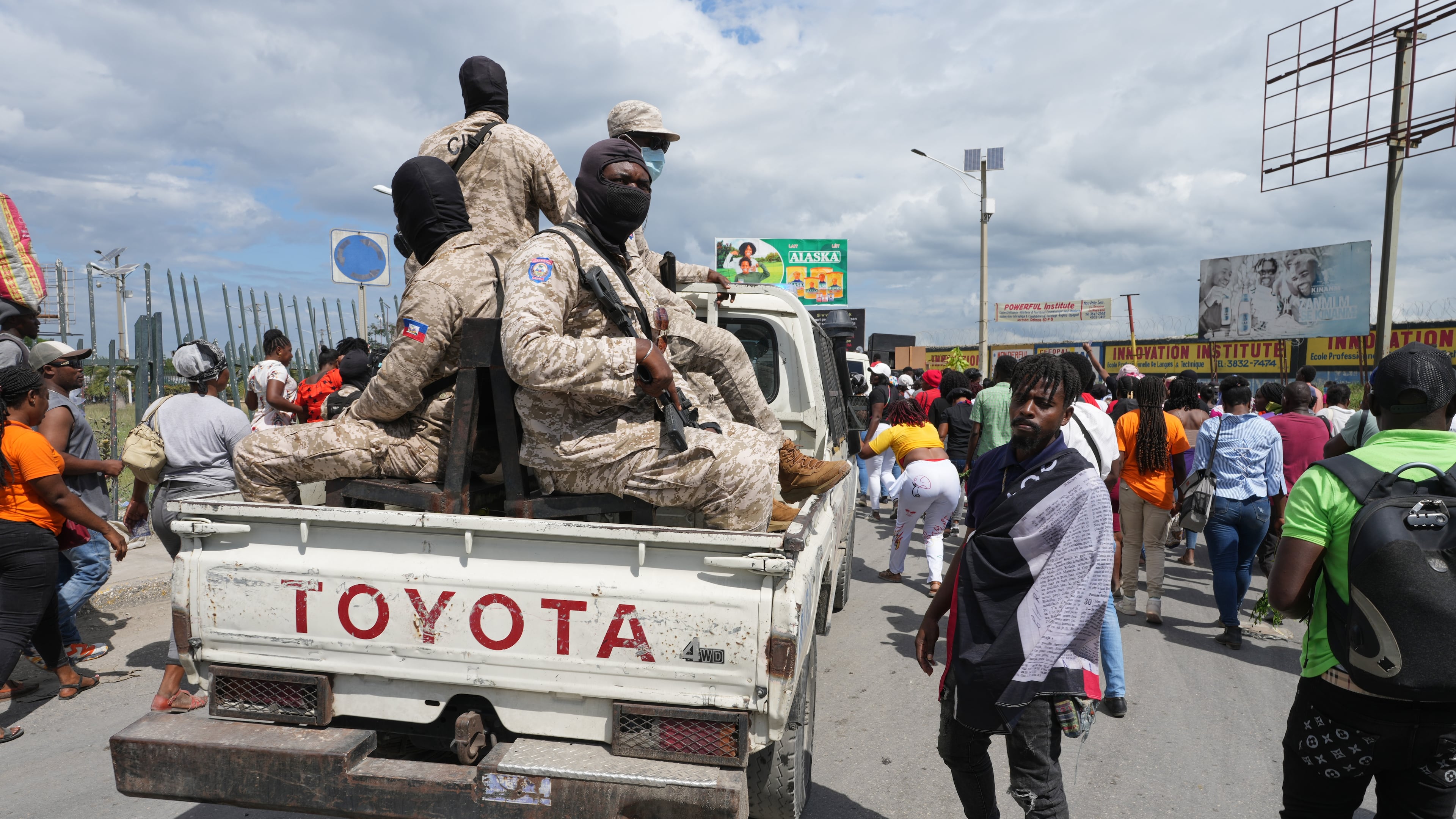 National Police patrol alongside a march by factory workers demanding a salary increase in Port-au-Prince, Haiti, Monday, April 13, 2026. (AP Photo/Odelyn Joseph)