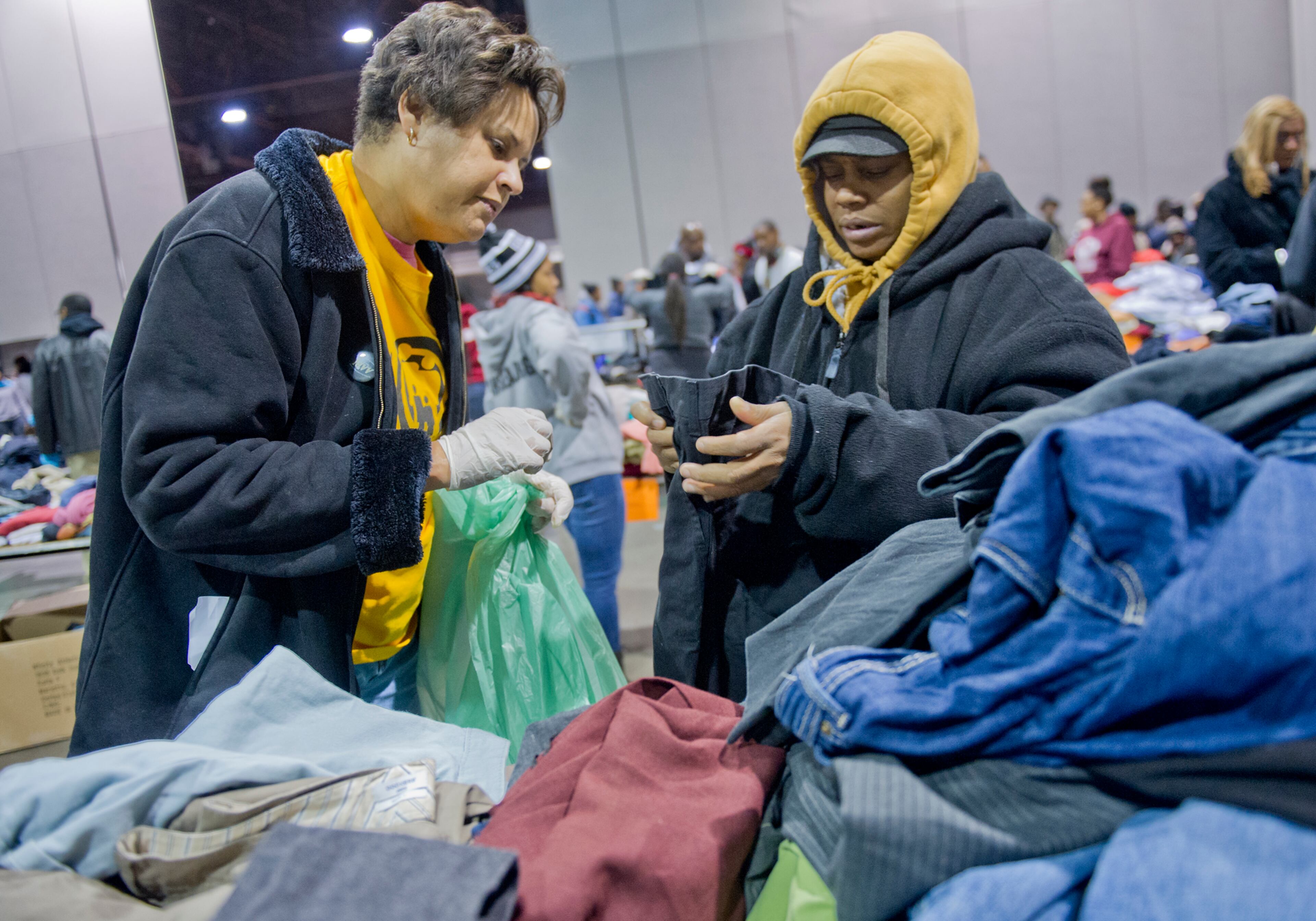 Monique Valrie-White (right) picks out some new clothes with the help of Kathryn Whitbourne during the Hosea Feed the Hungry and Homeless annual Thanksgiving meal at the Georgia World Congress Center in Atlanta on Nov. 28, 2013.