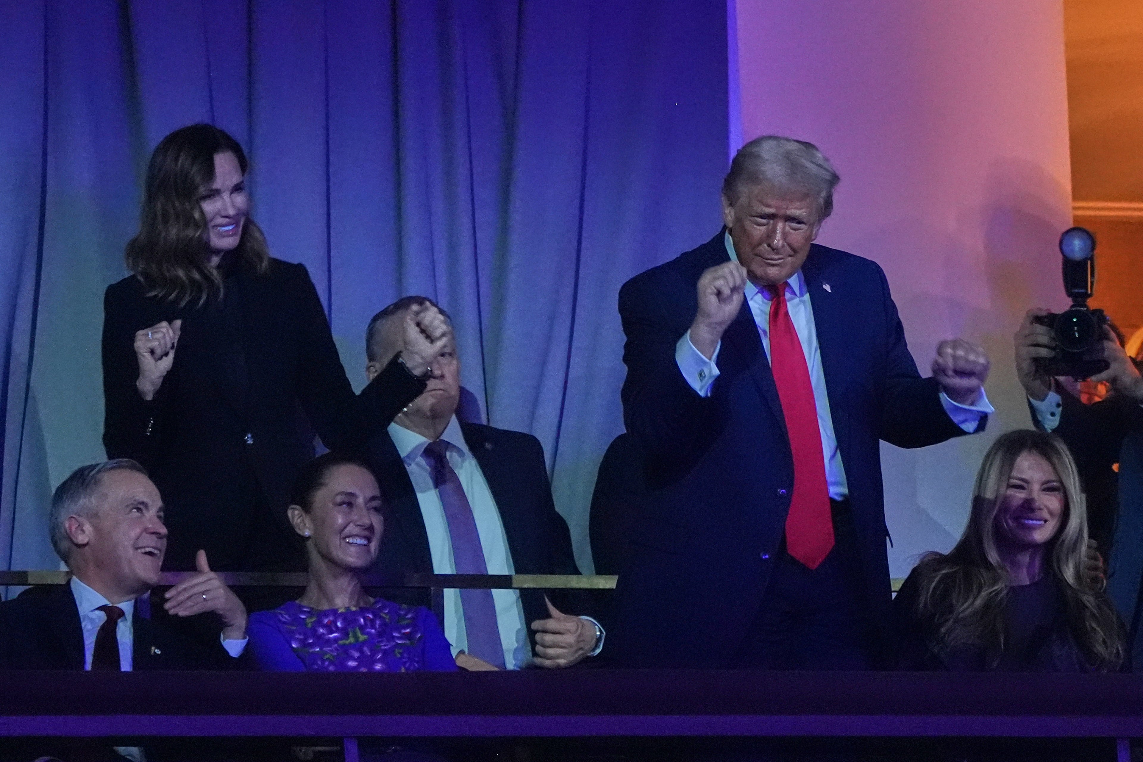 President Donald Trump dances to the Village People's performance as Canadian Prime Minister Mark Carney, Mexican President Claudia Sheinbaum and First Lady Melania smile during the draw for the 2026 soccer World Cup at the Kennedy Center in Washington, Friday, Dec. 5, 2025. (AP Photo/Jacquelyn Martin)