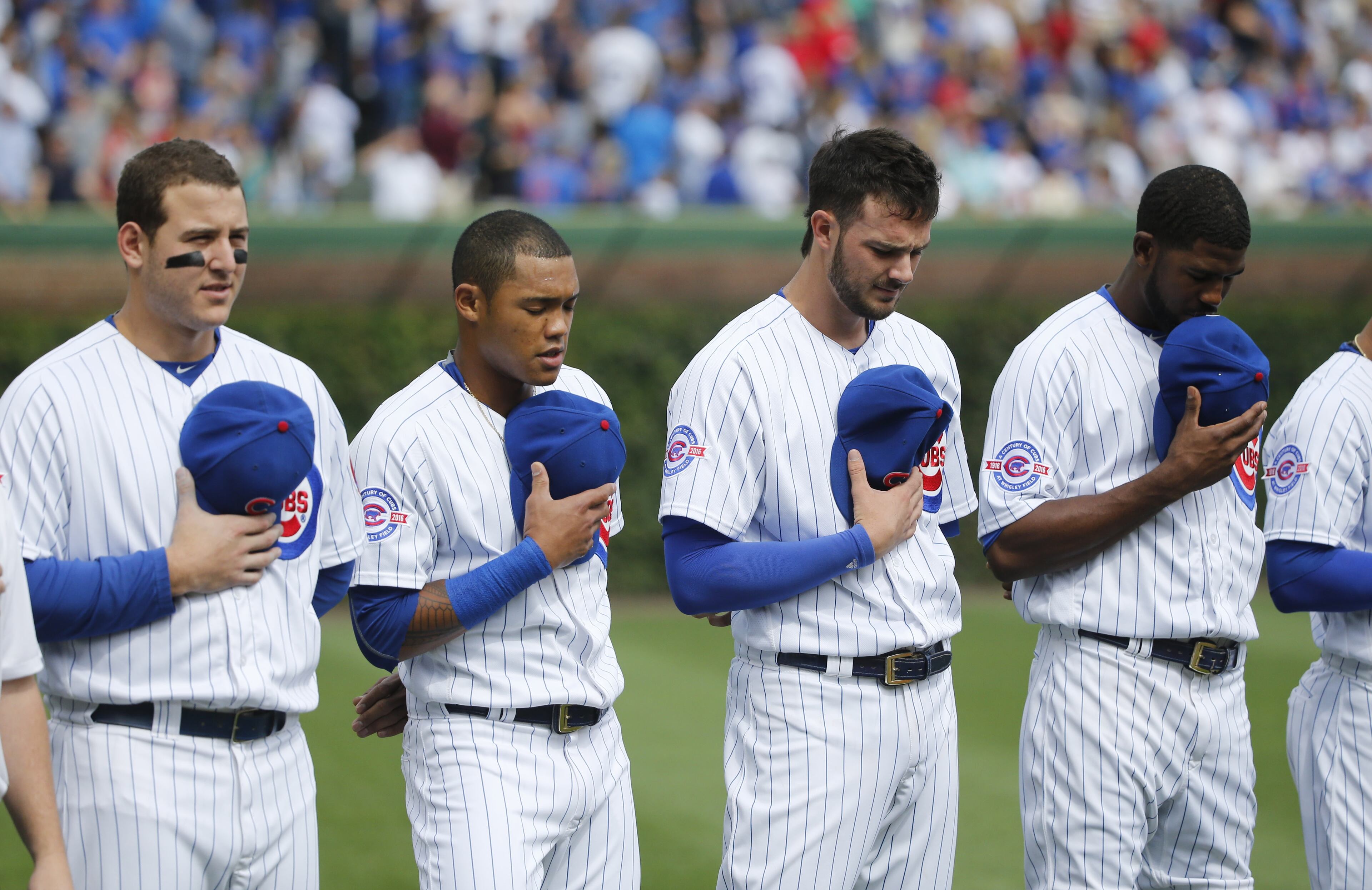 Chicago Cubs' players from left, Anthony Rizzo, Addison Russell, Kris Bryant, and Dexter Fowler line up for the national anthem before a baseball game against the St. Louis Cardinals Friday, Sept. 23, 2016, in Chicago. (AP Photo/Charles Rex Arbogast)