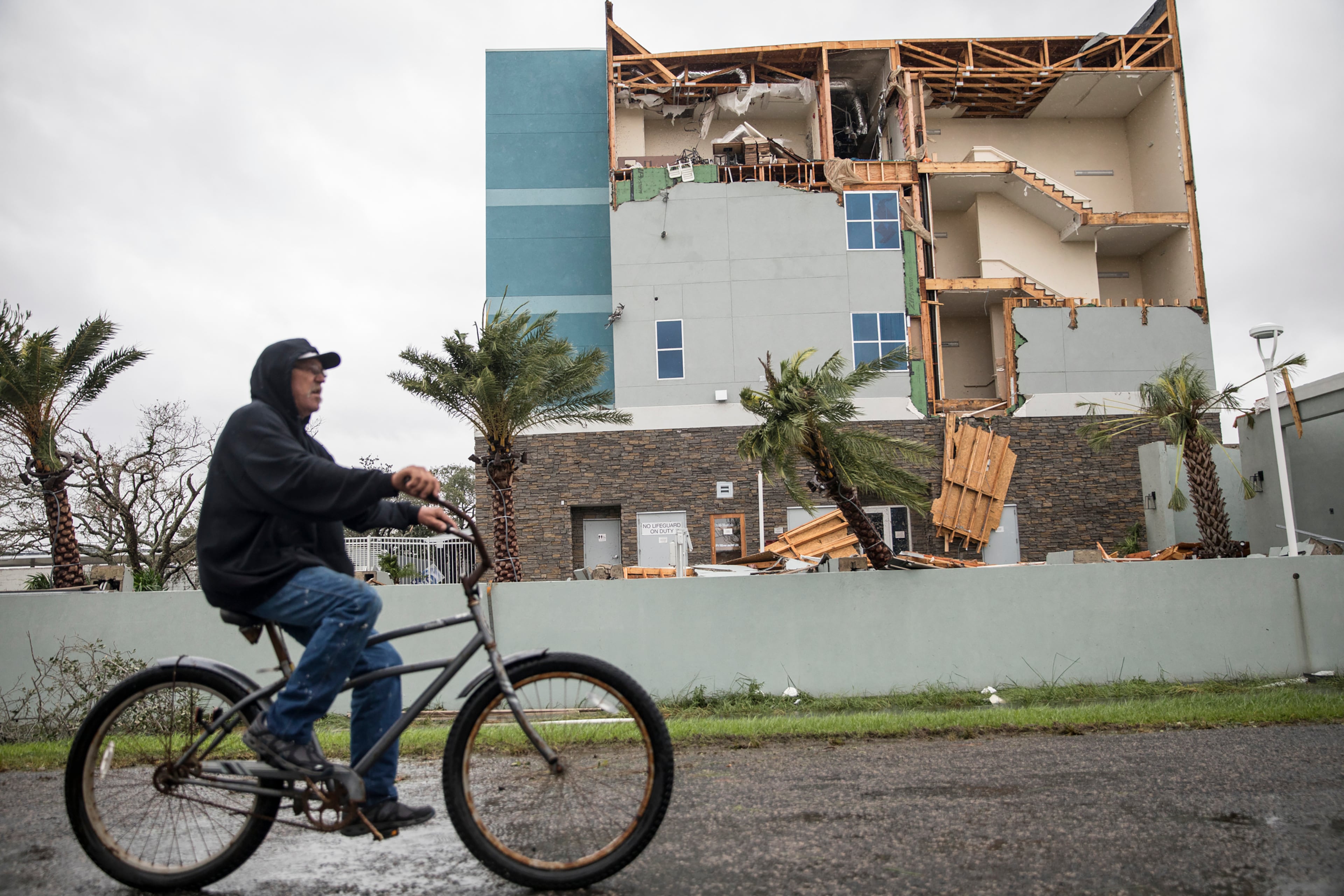 Jeff Page rides his bike past a hotel damaged during Hurricane Harvey in Rockport, Texas, Aug. 26, 2017. Rockport, a coastal city of about 10,000, was in the hurricanes path when it came ashore late Friday. (Tamir Kalifa/The New York Times)