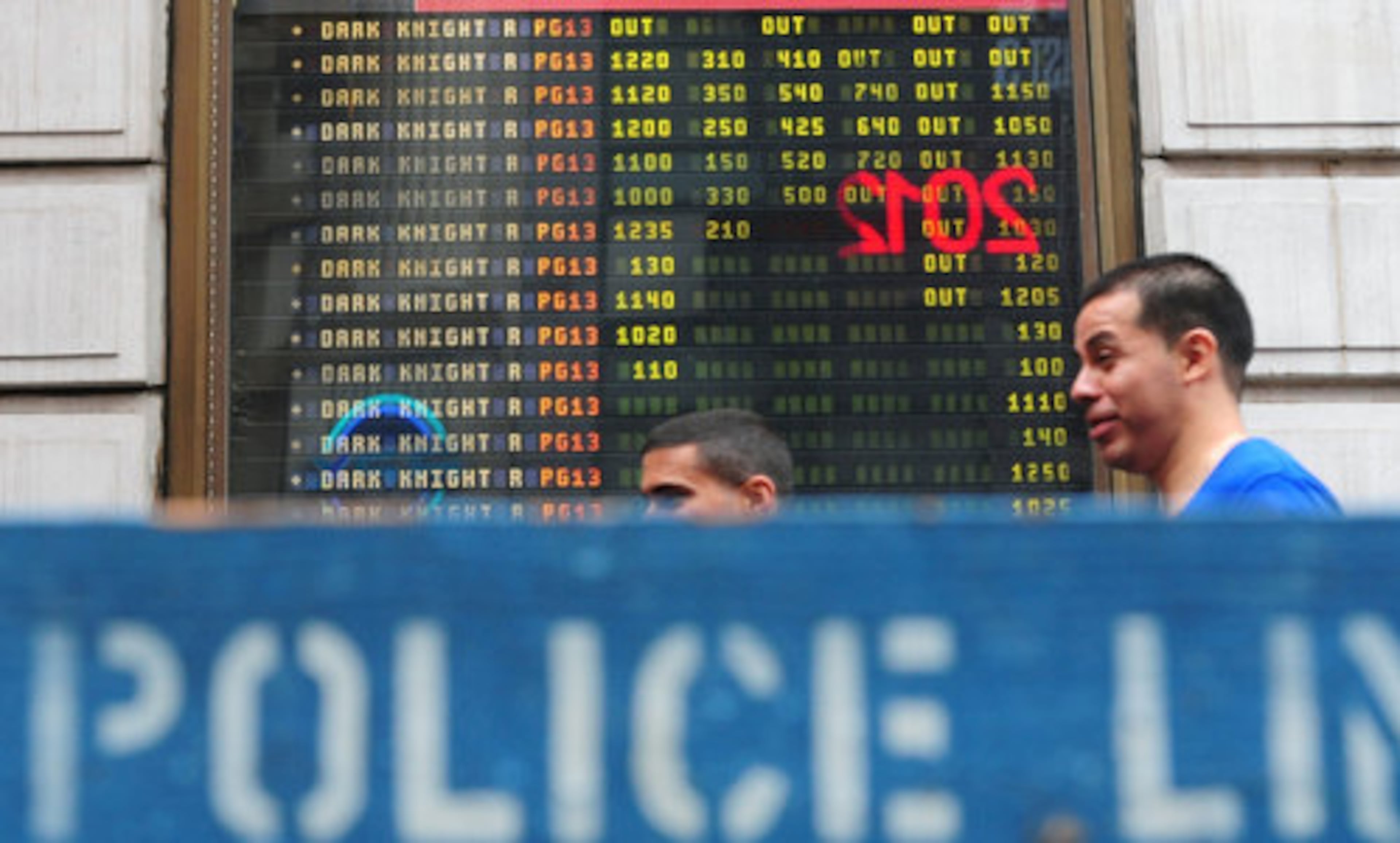 People look over show times at the AMC 25 Theatres in Times Square in Manhattan, Friday, July 20, 2012, following the Batman ''Dark Knight Rises'' theater shooting in Aurora, Colorado.