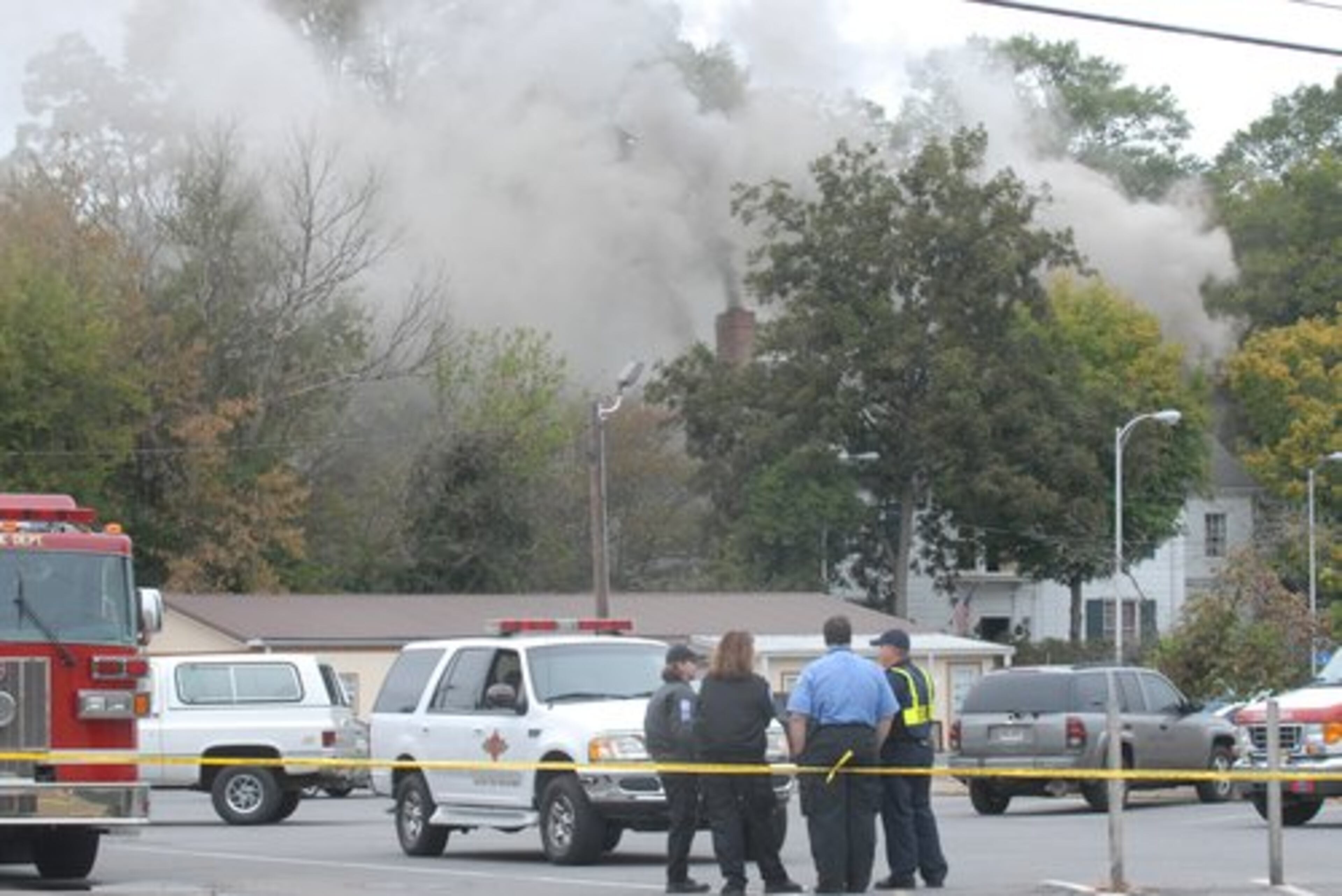 Law enforcement personnel gather outside the law firm of McCamy, Phillips, Tuggle & Fordham as the building burns in Dalton.