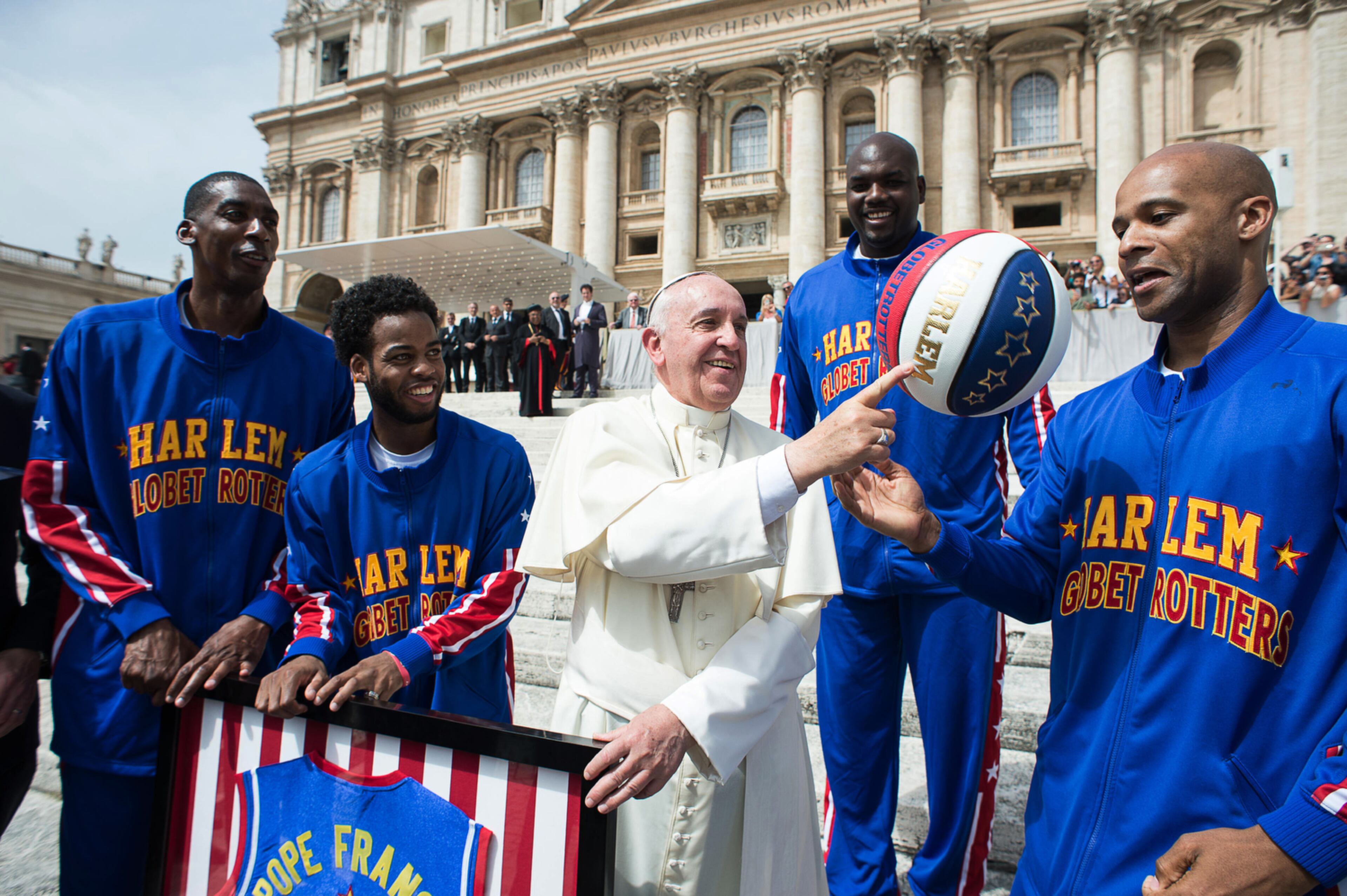 POPE GOT SKILLS--Harlem Globetrotters' Hi-Lite Bruton, left, Ant Atitkson, second from left, Big Easy Lofton, second from right, look at teammate Flight Time Lang, right, helping Pope Francis spin the ball on his finger as they meet during the general audience in St. Peter's Square at the Vatican, Wednesday, May 6, 2015. (L'Osservatore Romano/Pool Photo via AP)