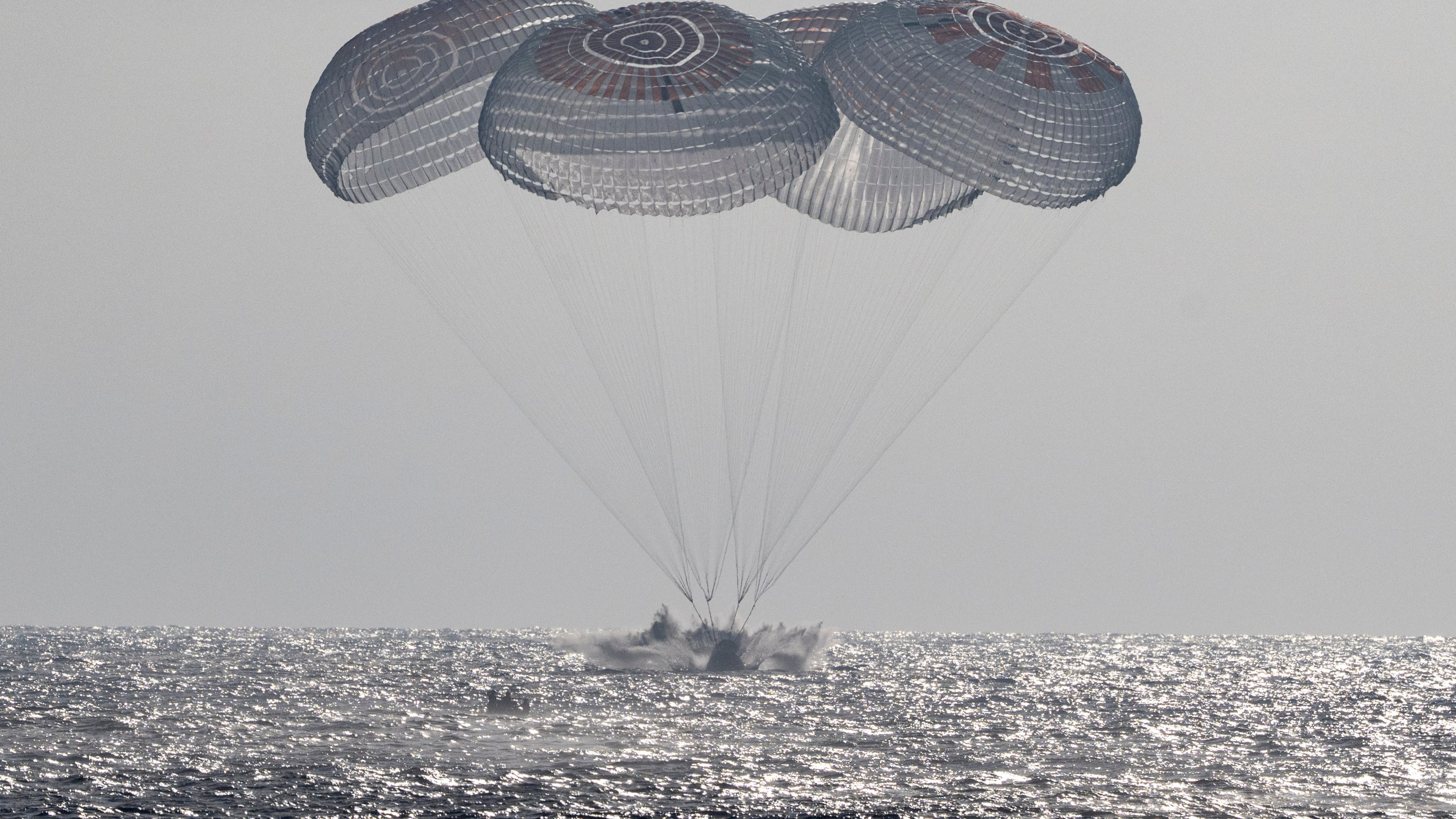 In this photo provided by NASA, the SpaceX Crew Dragon Freedom spacecraft splashes down in the Pacific Ocean off the coast of California on Thursday, Oct. 8, 2026, returning from the International Space Station. (Keegan Barber/NASA via AP)