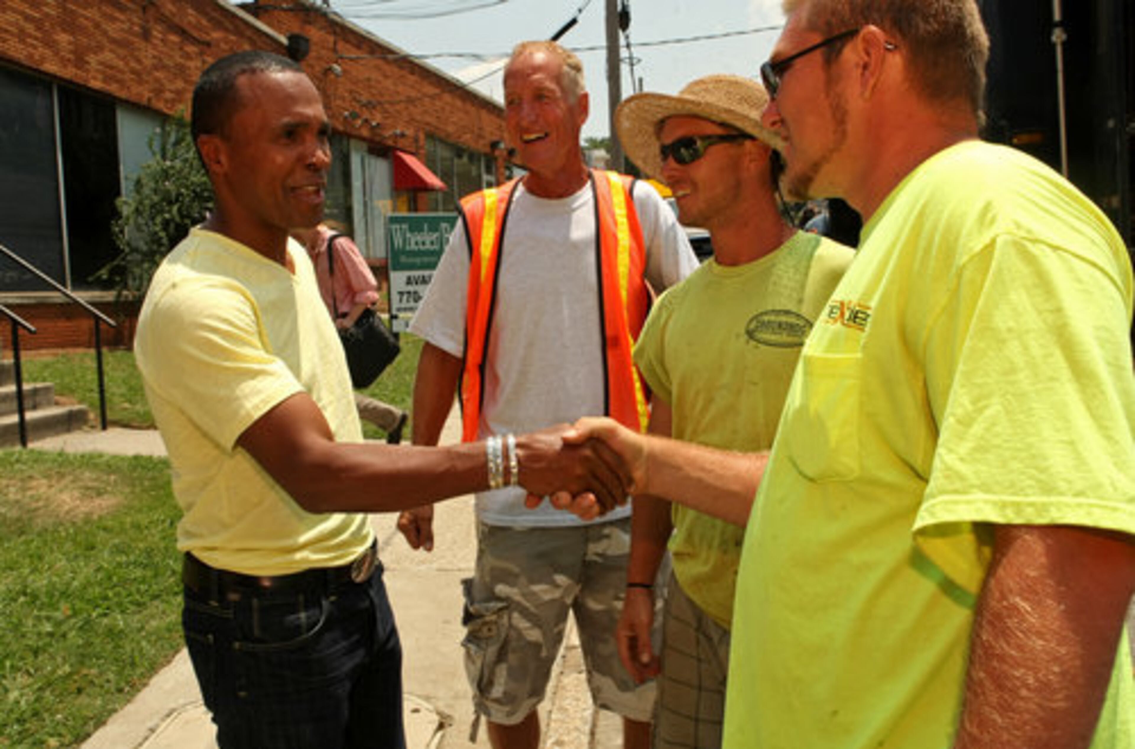 Construction workers from Groundhog Directional Boring greet Sugar Ray Leonard outside the Atlanta Art of Boxing center.