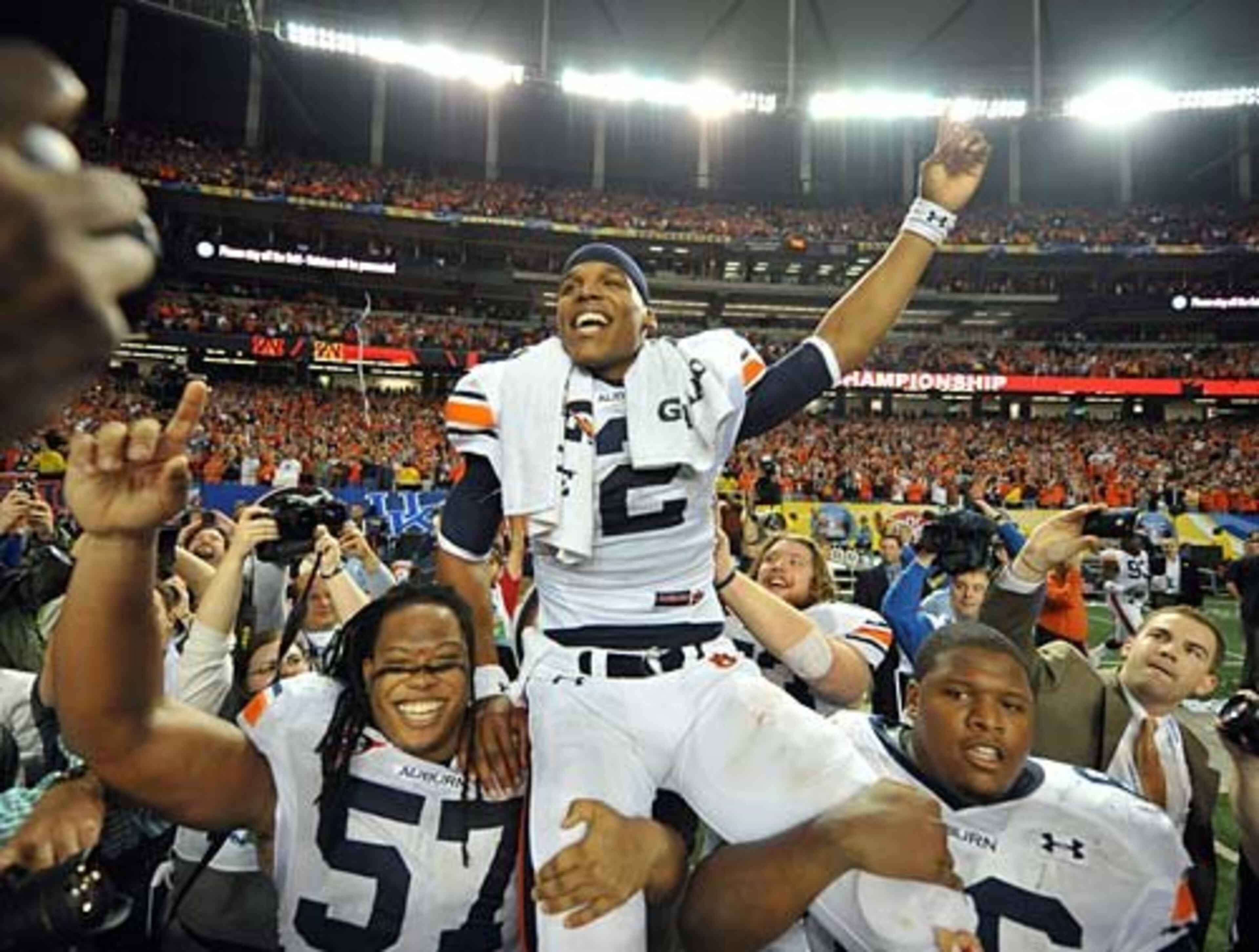 Auburn Tigers quarterback Cameron Newton (2) is carried off the field by offensive linemen Byron Isom (57) and Mike Berry (66) during the SEC Championship at the Georgia Dome Saturday December 4, 2010.