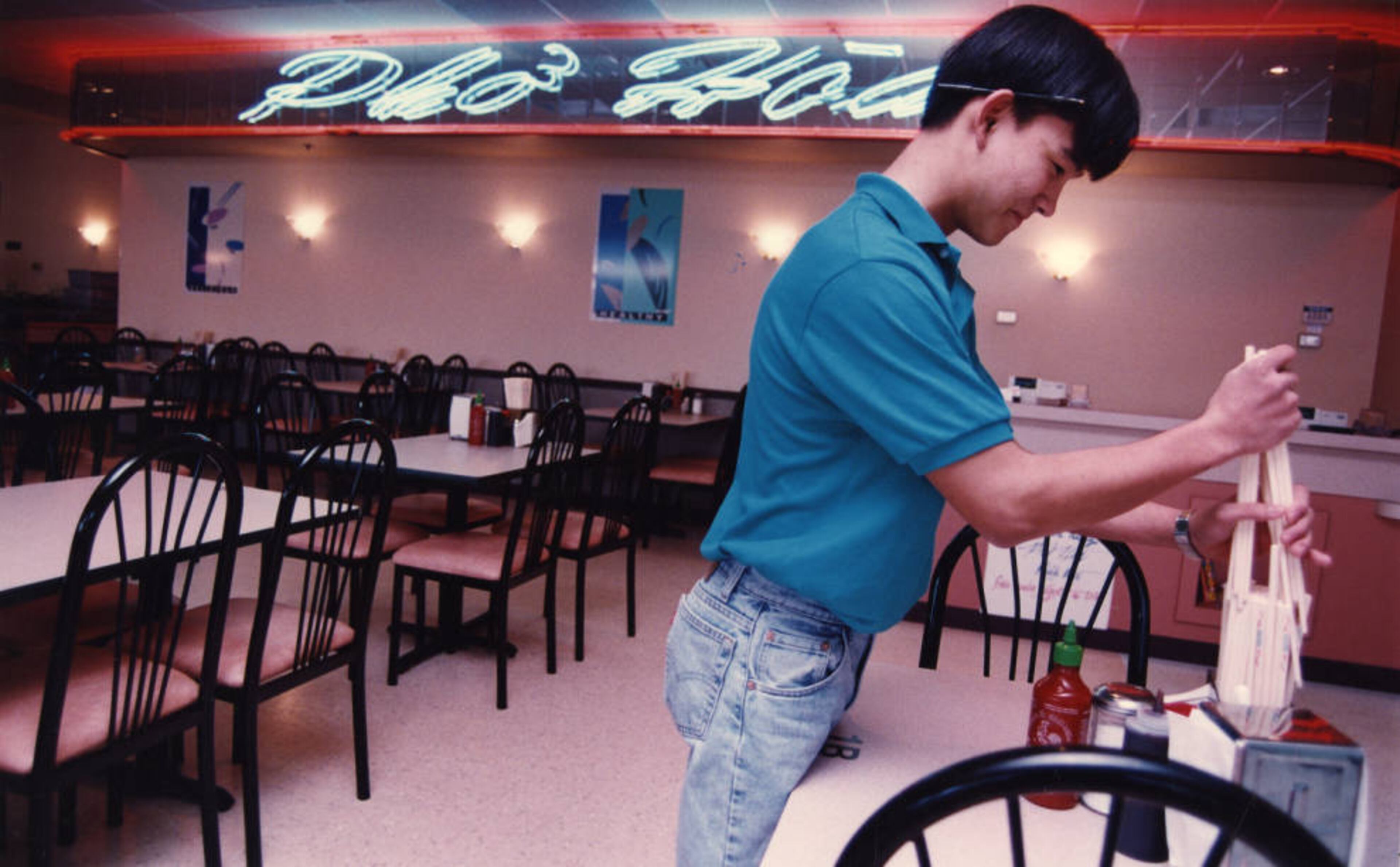 Thai Giao, 18, stocks chopsticks in the dining area at Pho Hoa, which was in Asian Square at 5150 Buford Highway for many years.