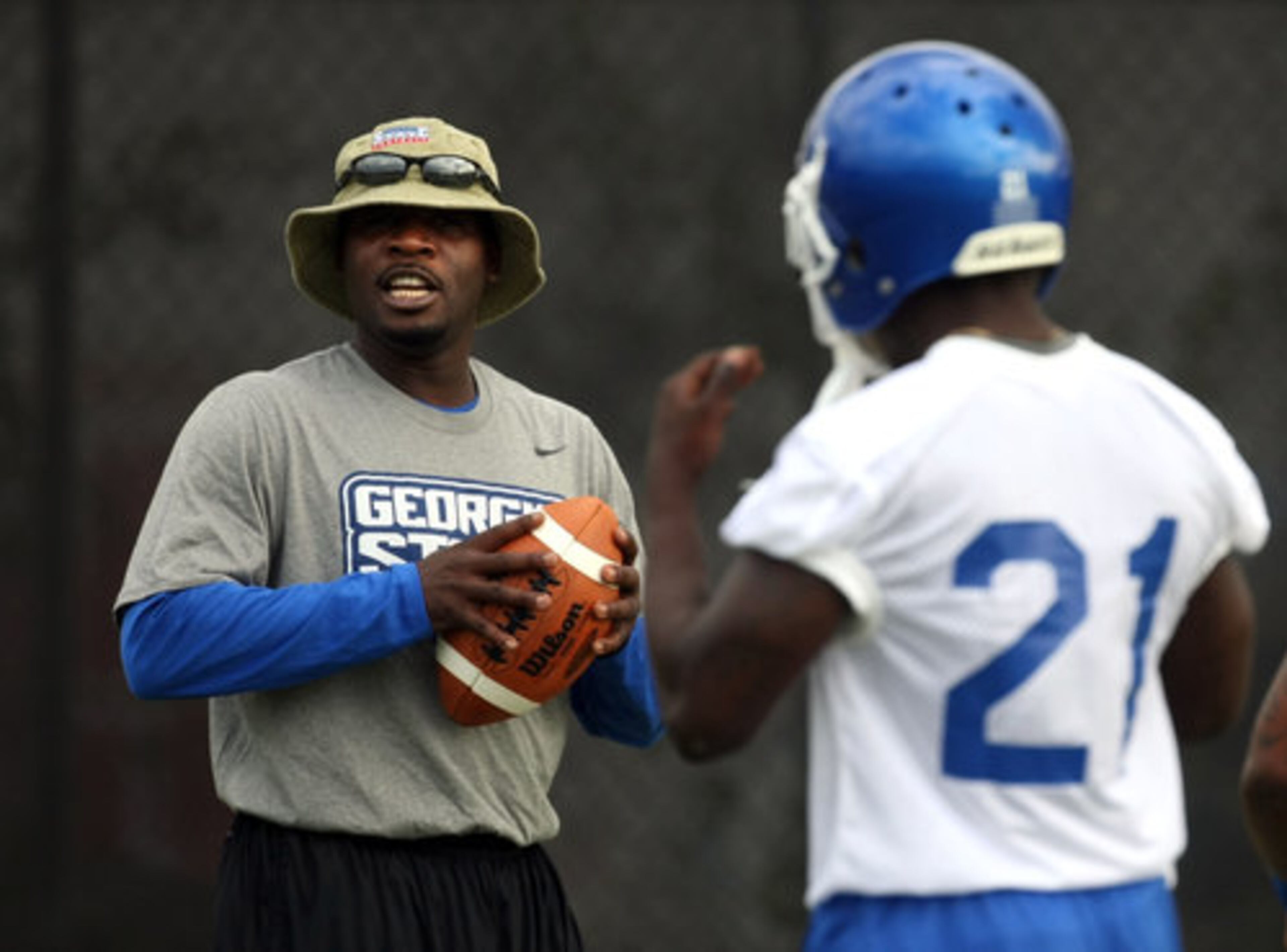 Georgia State University Running Backs coach Joe Hamilton, left, talks with running back Travis Evans (21) during GSU's first practice at the GSU Football Practice Complex Thursday morning in Atlanta, Ga., August 4, 2011. Hamilton, the former Georgia Tech All-American quarterback, is in his second year as an assistant coach at GSU.