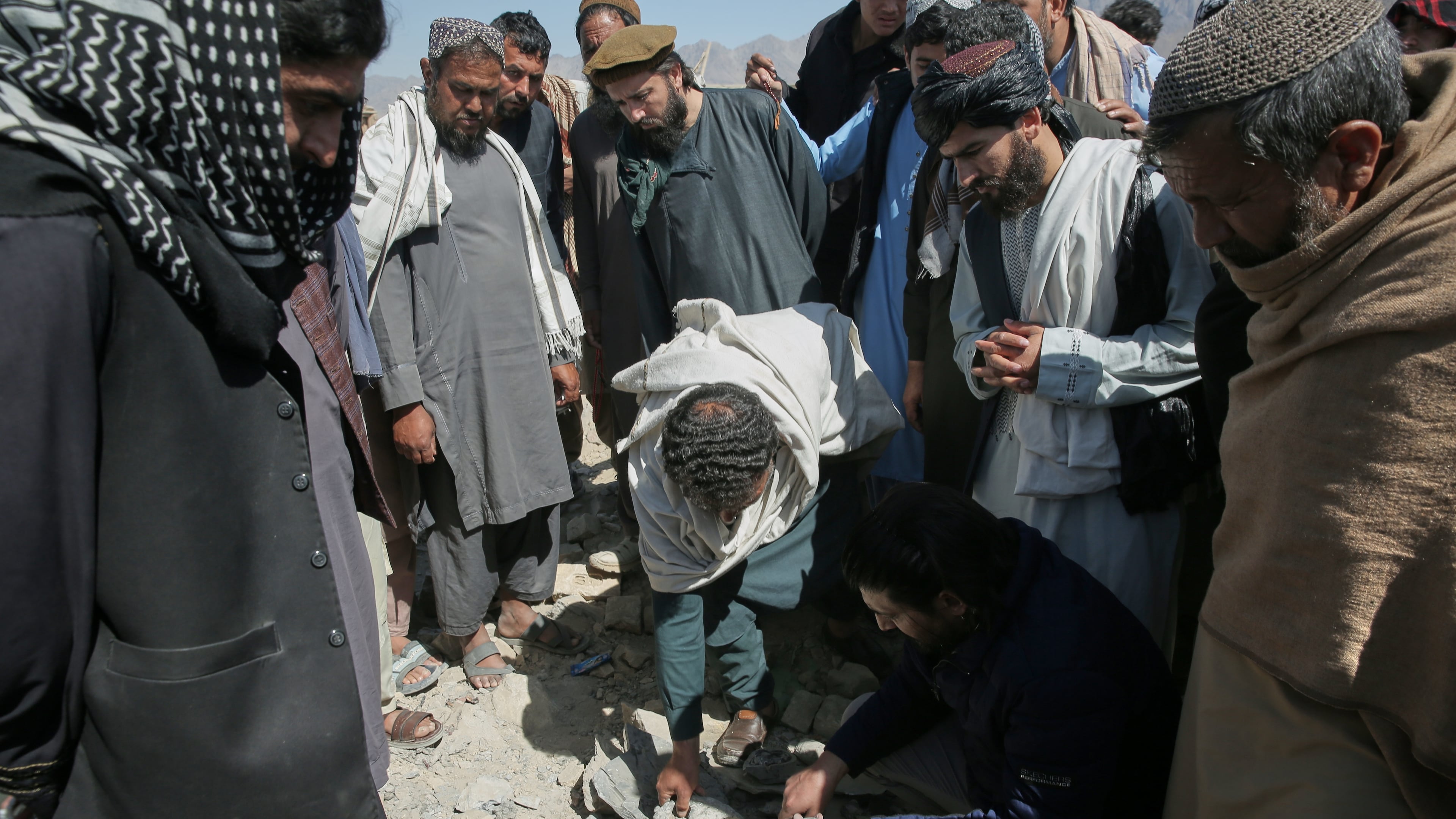 Residents and Taliban police gather the remains of a projectile at the site of a strike in Kabul, Afghanistan, Friday, March 13, 2026. (AP Photo/Barackatullah Popal)