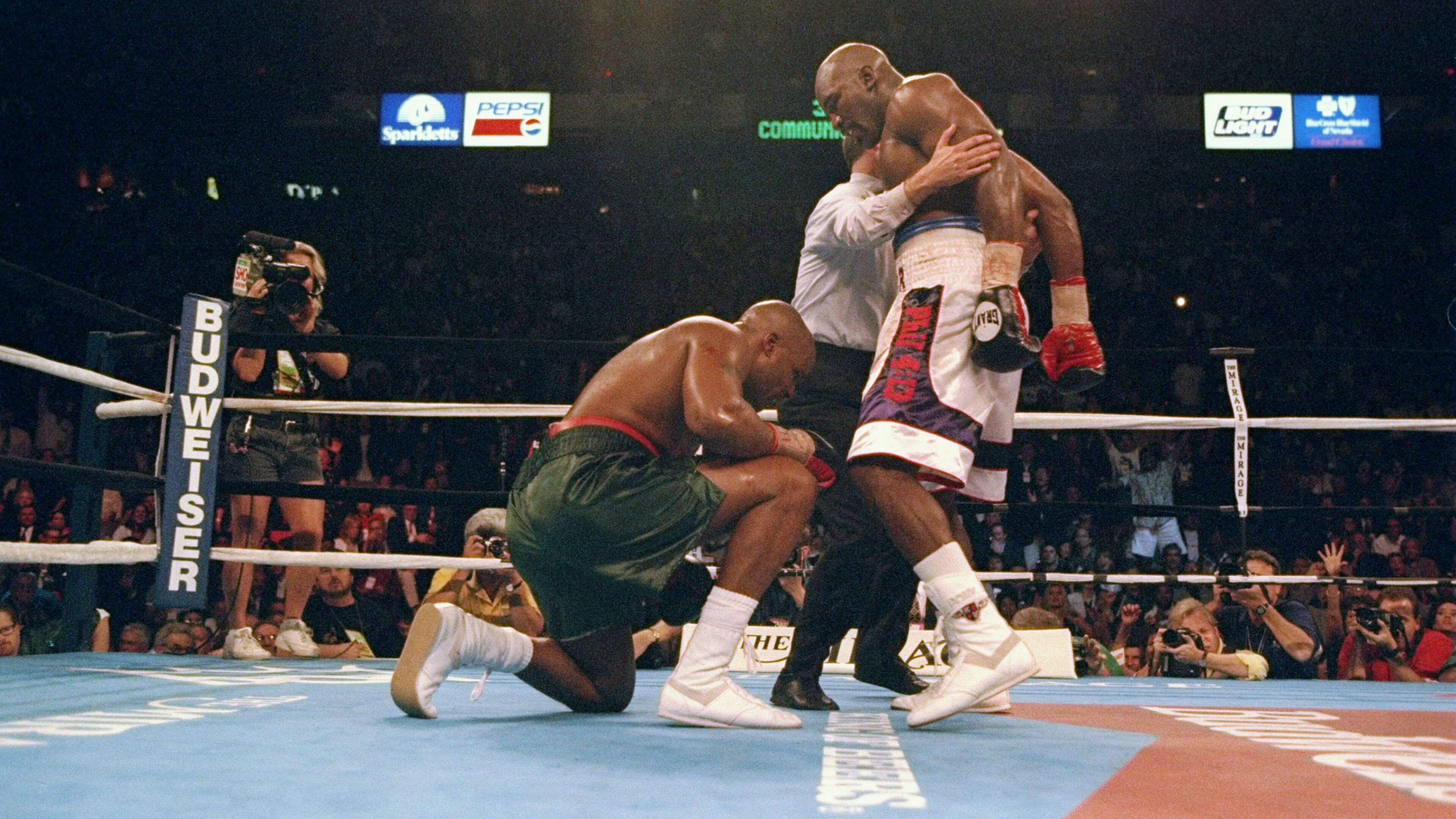 Evander Holyfield knocks down Michael Moorer during a fight at the Thomas and Mack Center in Las Vegas,. Holyfield won the fight by a technical knockout.