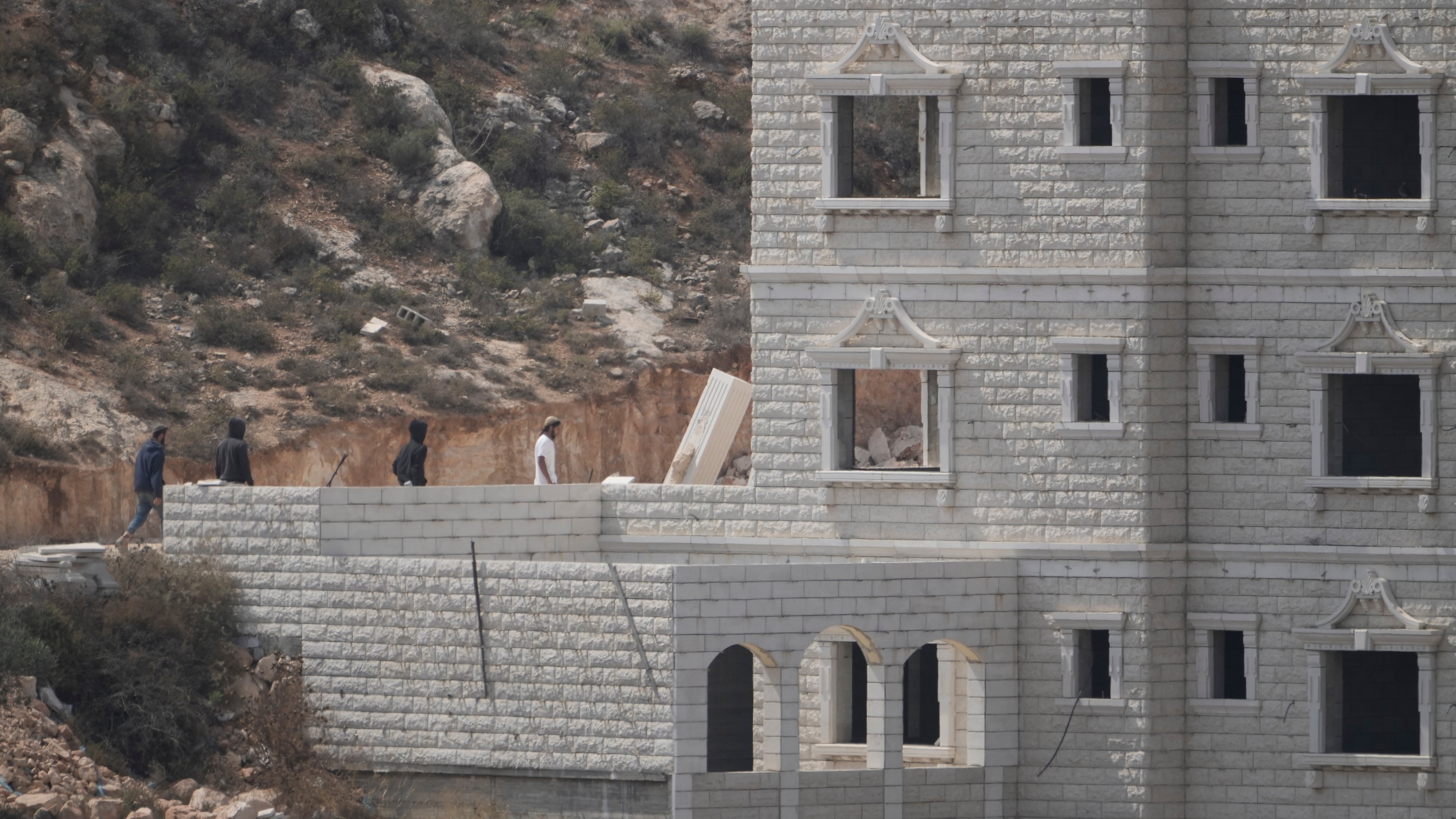 Israeli settlers enter Palestinian properties in the occupied West Bank village of Qusra, Saturday, Aug. 29, 2026. (AP Photo/Majdi Mohammed)