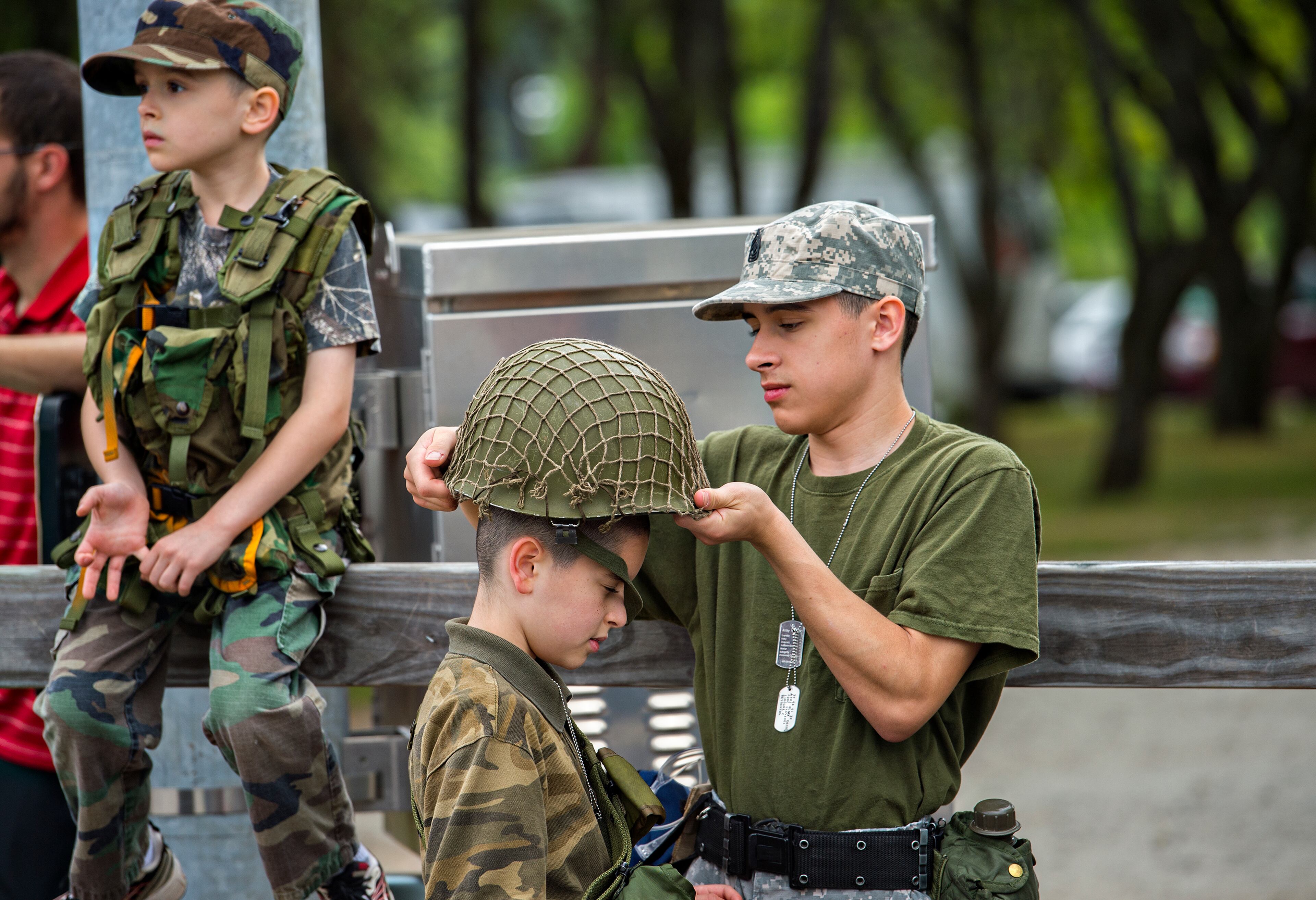 May 25, 2015 Dacula - Timothy Beauchamp (right) helps his brother Samuel with his helmet as they and their other brother Jonathan wait for the start of the annual Dacula Memorial Day Parade on Monday, May 25, 2015. The parade, now in its 22nd year, remains the only Memorial Day parade in Metro Atlanta, largest in the the state of Georgia and one of the largest in the nation with more than 150 units participating this year. JONATHAN PHILLIPS / SPECIAL