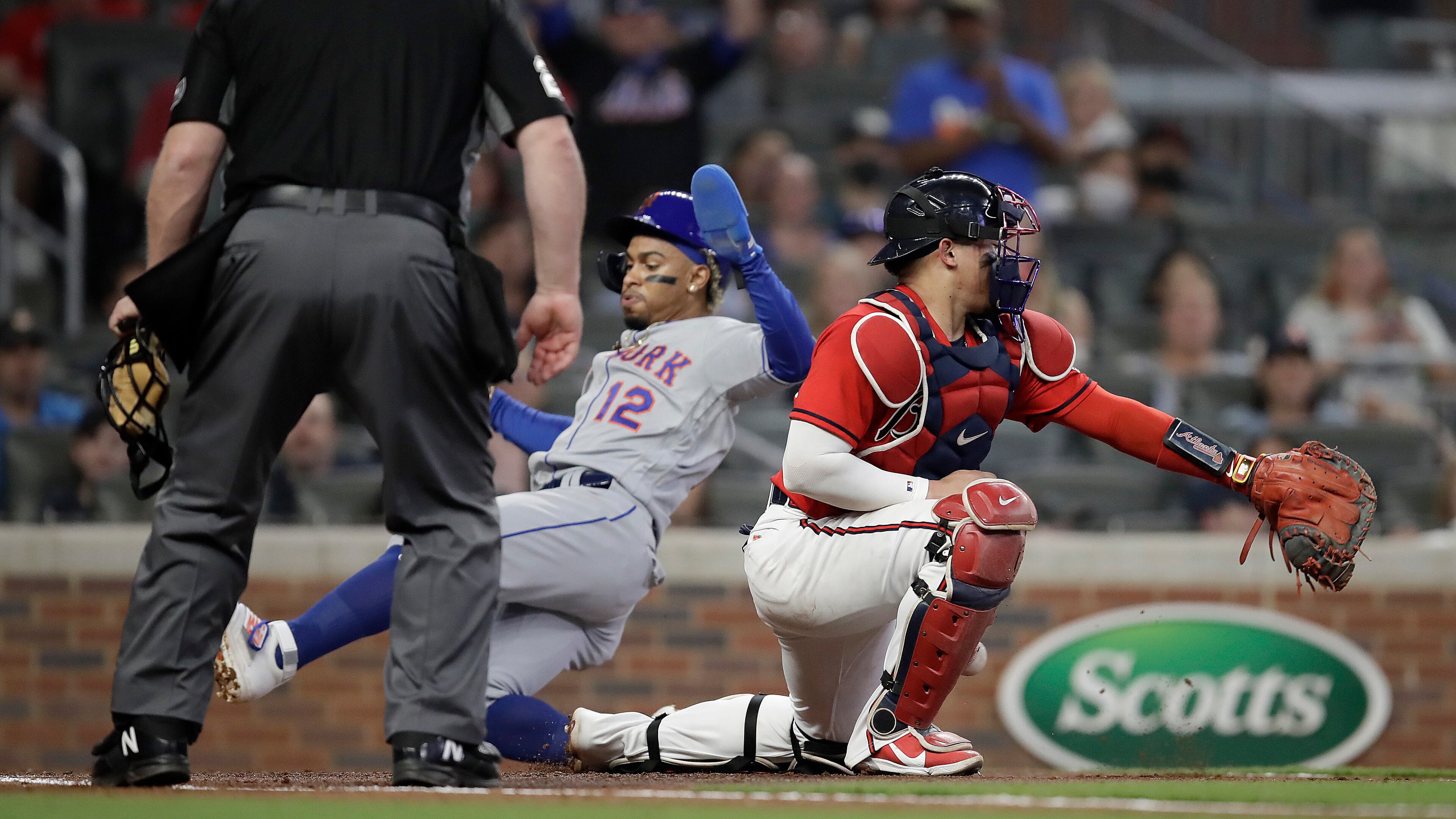 New York Mets' Francisco Lindor (12) slides to score past Atlanta Braves catcher William Contreras in the fourth inning of a baseball game Friday, Oct. 1, 2021, in Atlanta. (AP Photo/Ben Margot)