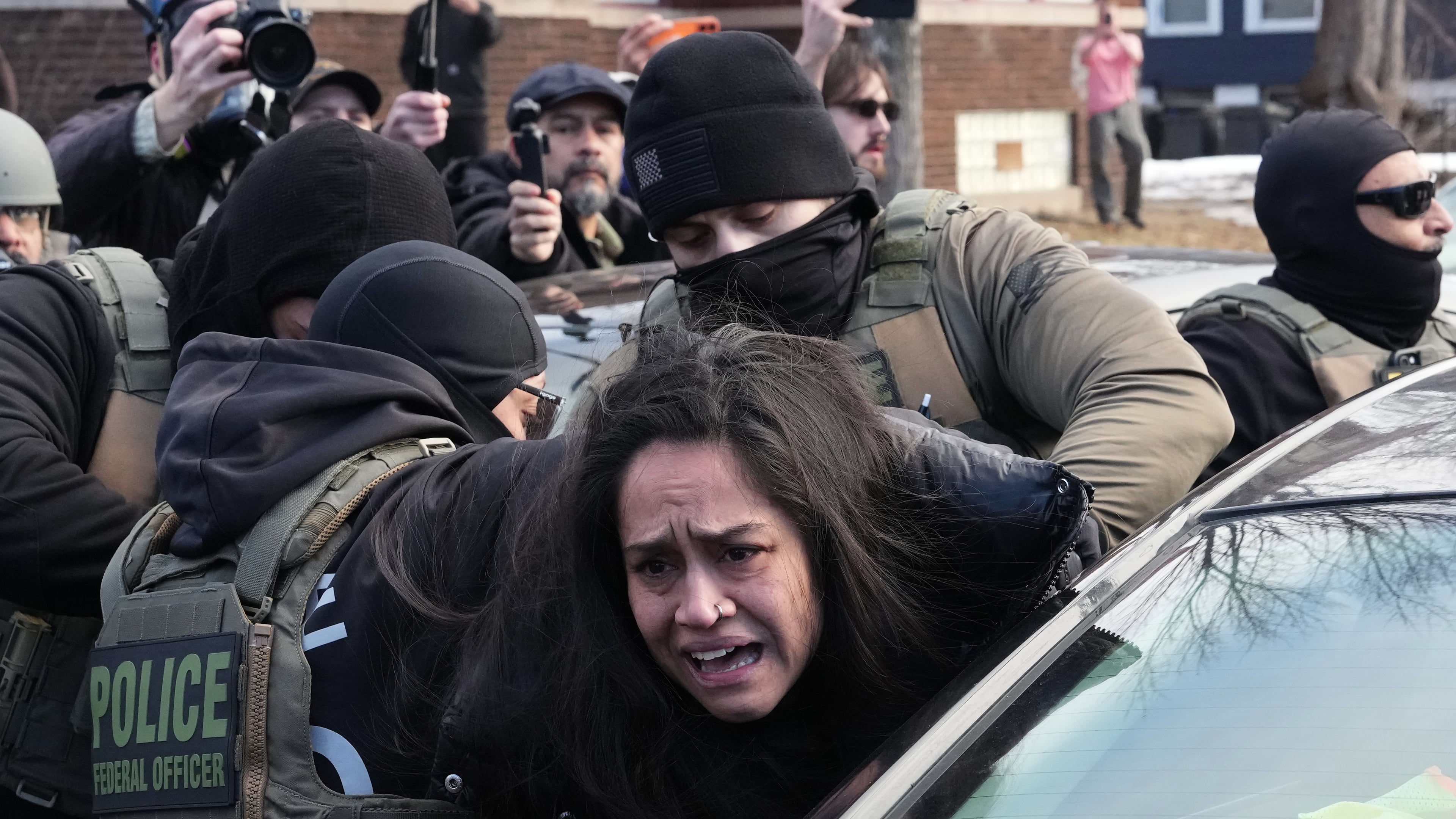 A person is detained by federal agents near the scene where Renee Good was fatally shot by an ICE officer last week, Tuesday, Jan. 13, 2026, in Minneapolis. (AP Photo/Adam Gray)