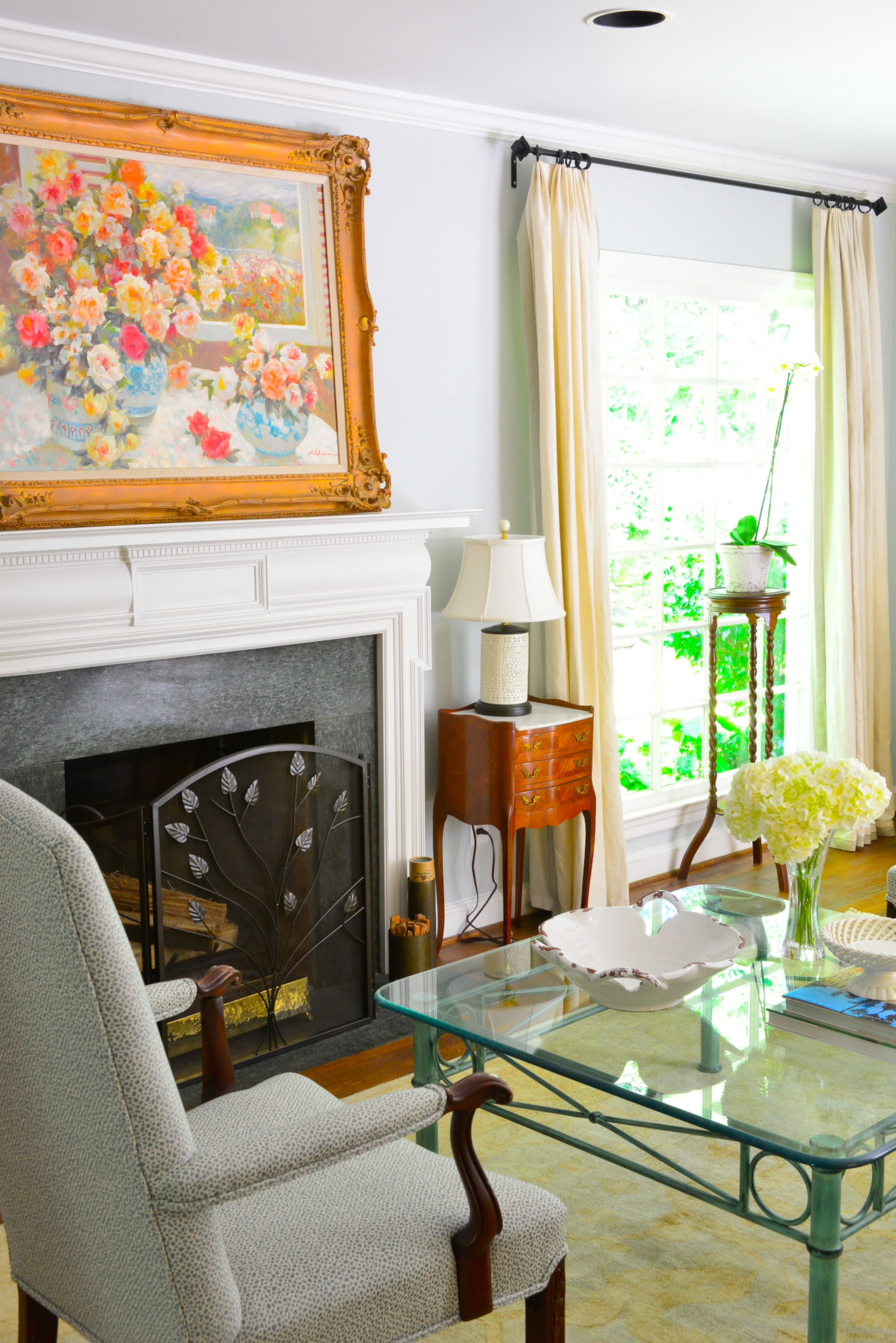The painting over the mantle in the living room of TJ and Catherine Callaway's Buckhead home was an original piece of art created for Catherine's grandmother. The floral scene connects with the gardens seen just beyond the living room.