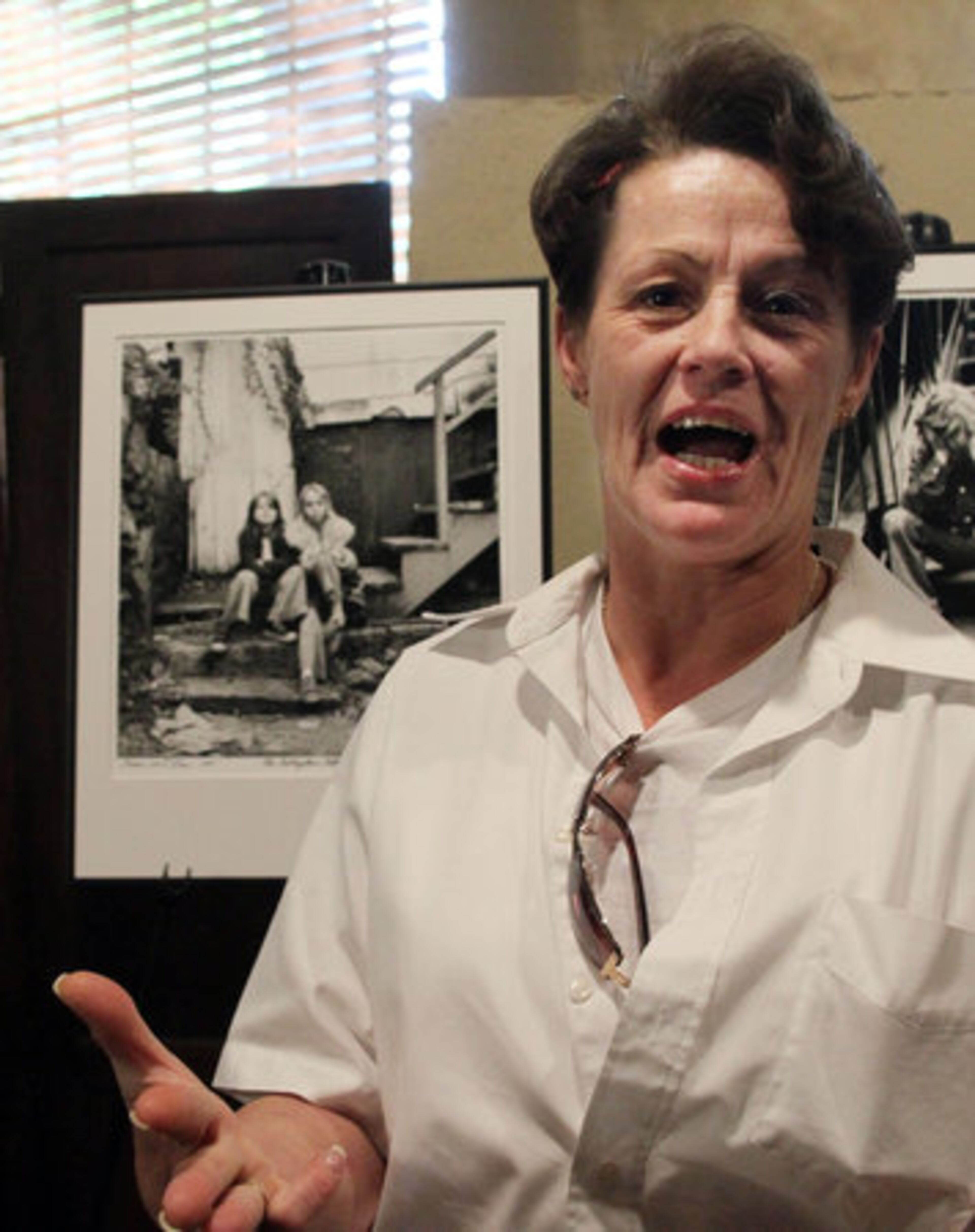 Former Cabbagetown resident Lisa Maddox talks about growing up in the neighborhood in front of a photo of her and her best friend Cassie Owens when they were 9 & 10 years old, respectively.