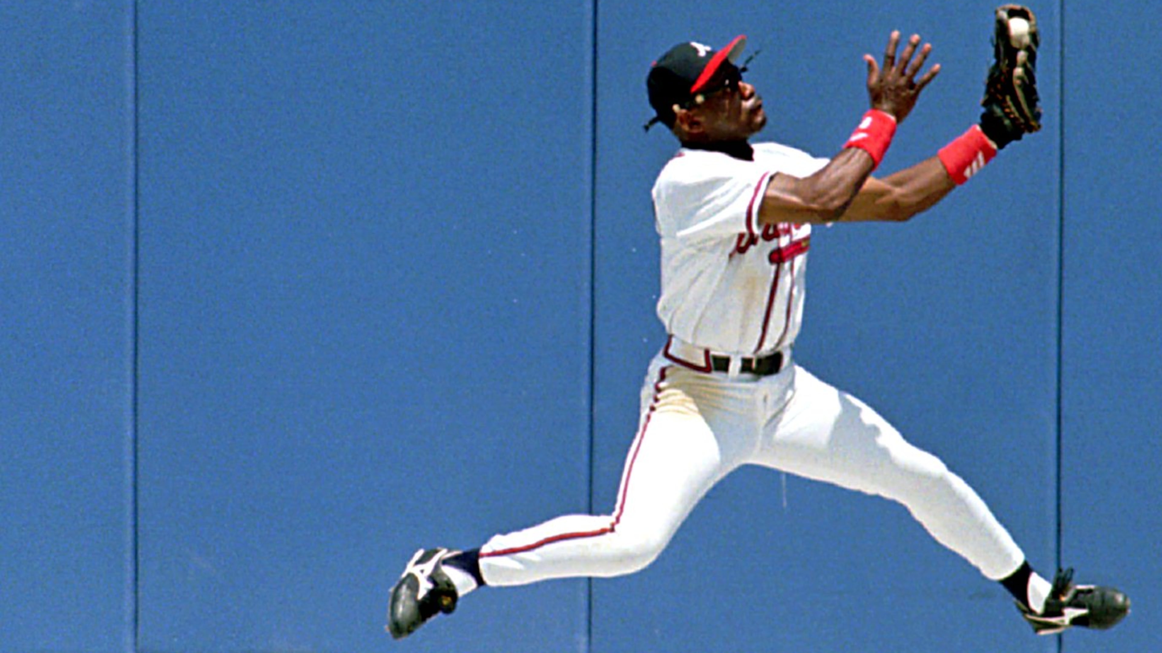Braves’ center fielder Marquis Grissom makes a catch at the warning track to rob Chicago Cubs’ third baseman Leo Gomez of a hit May 22, 1996.(AP Photo/Andrew Innerarity)