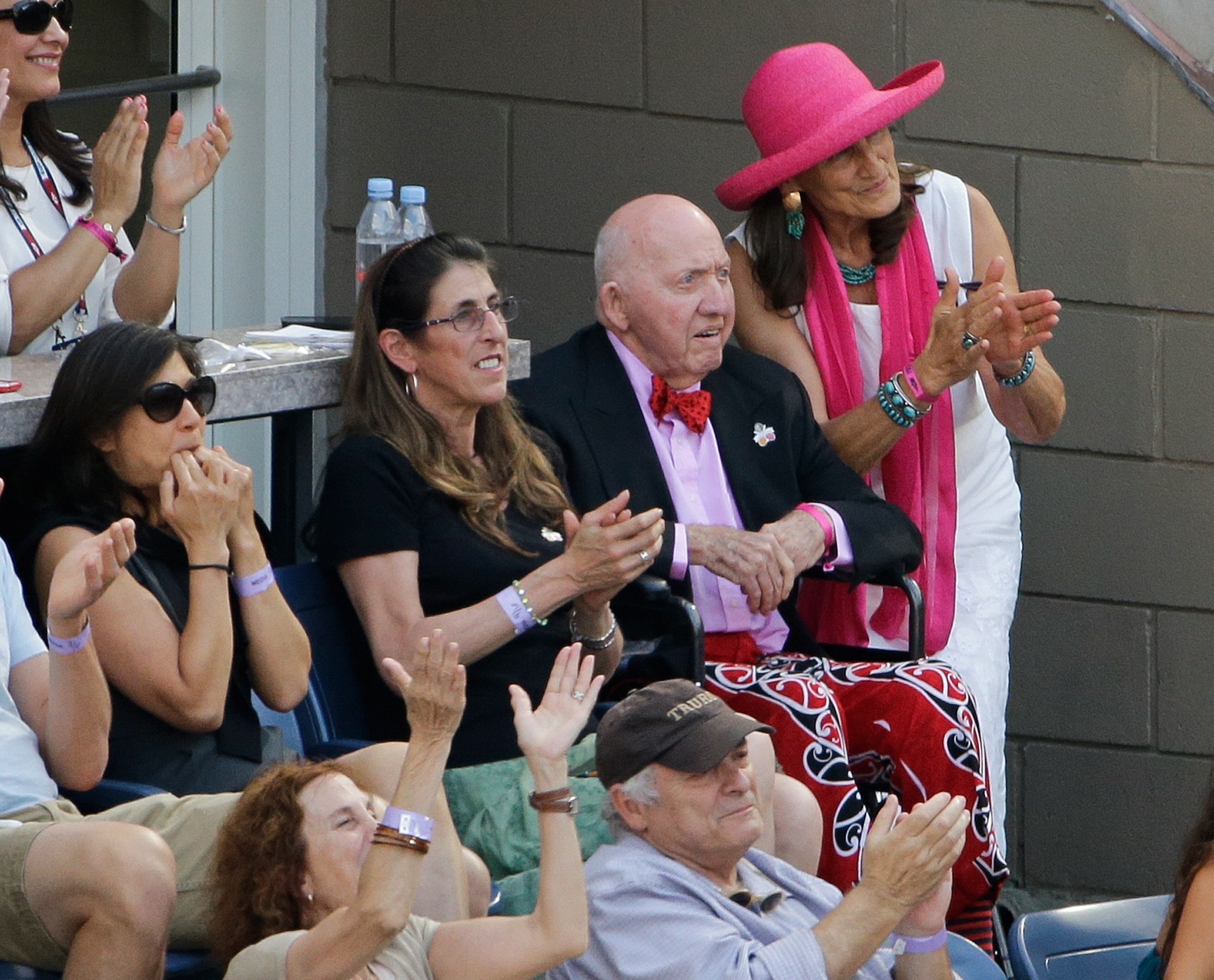 Tennis fans applaud television commentator and writer Bud Collins, second from right, during the fourth round of the U.S. Open tennis tournament, Sunday, Sept. 6, 2015, in New York. (AP Photo/Matt Rourke)