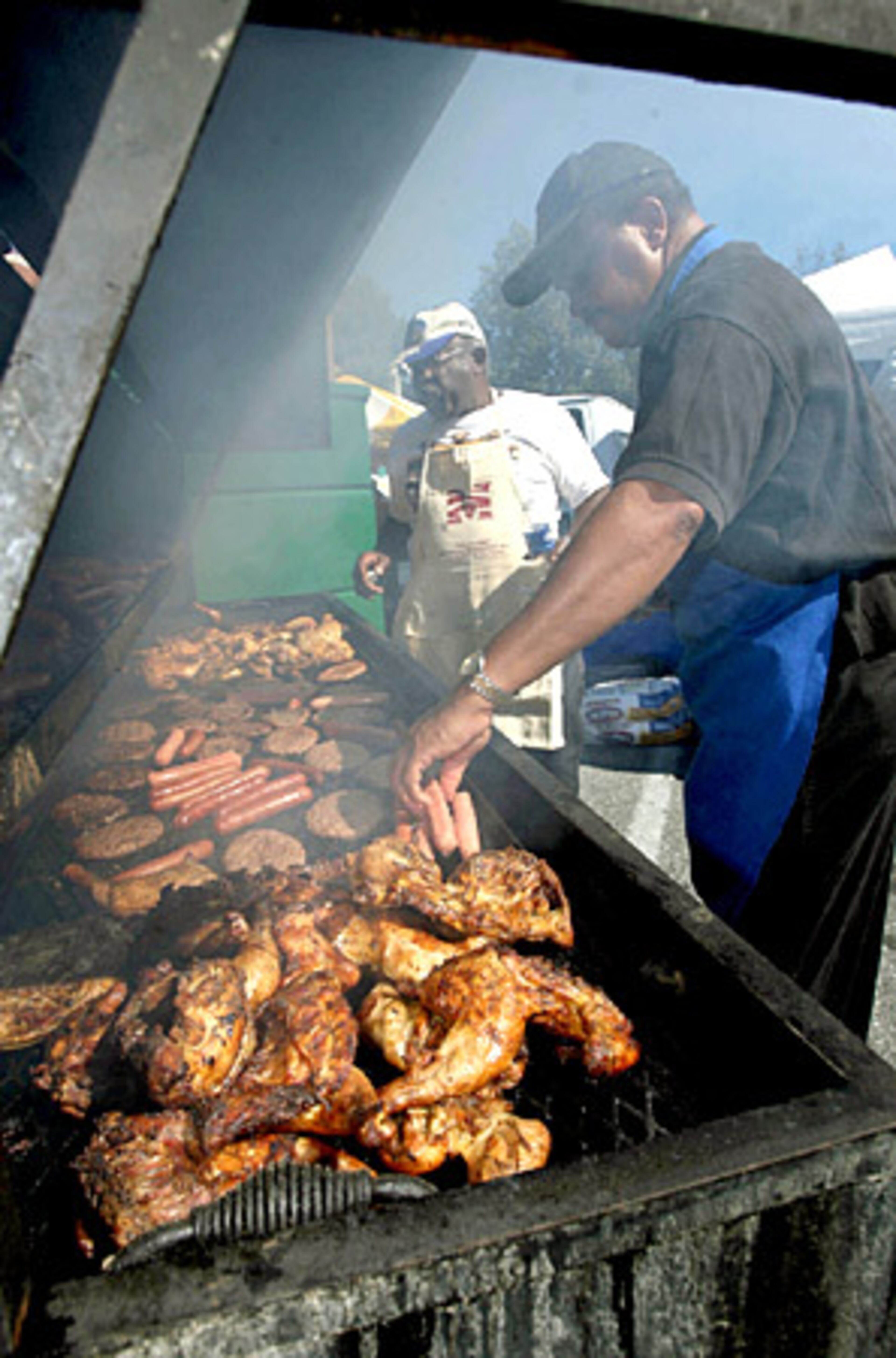 Bill White (left) and Bennie Boldon, both of Atlanta, grill various meats on a 10-foot charcoal grill at Morehouse before their game against Clark Atlanta.