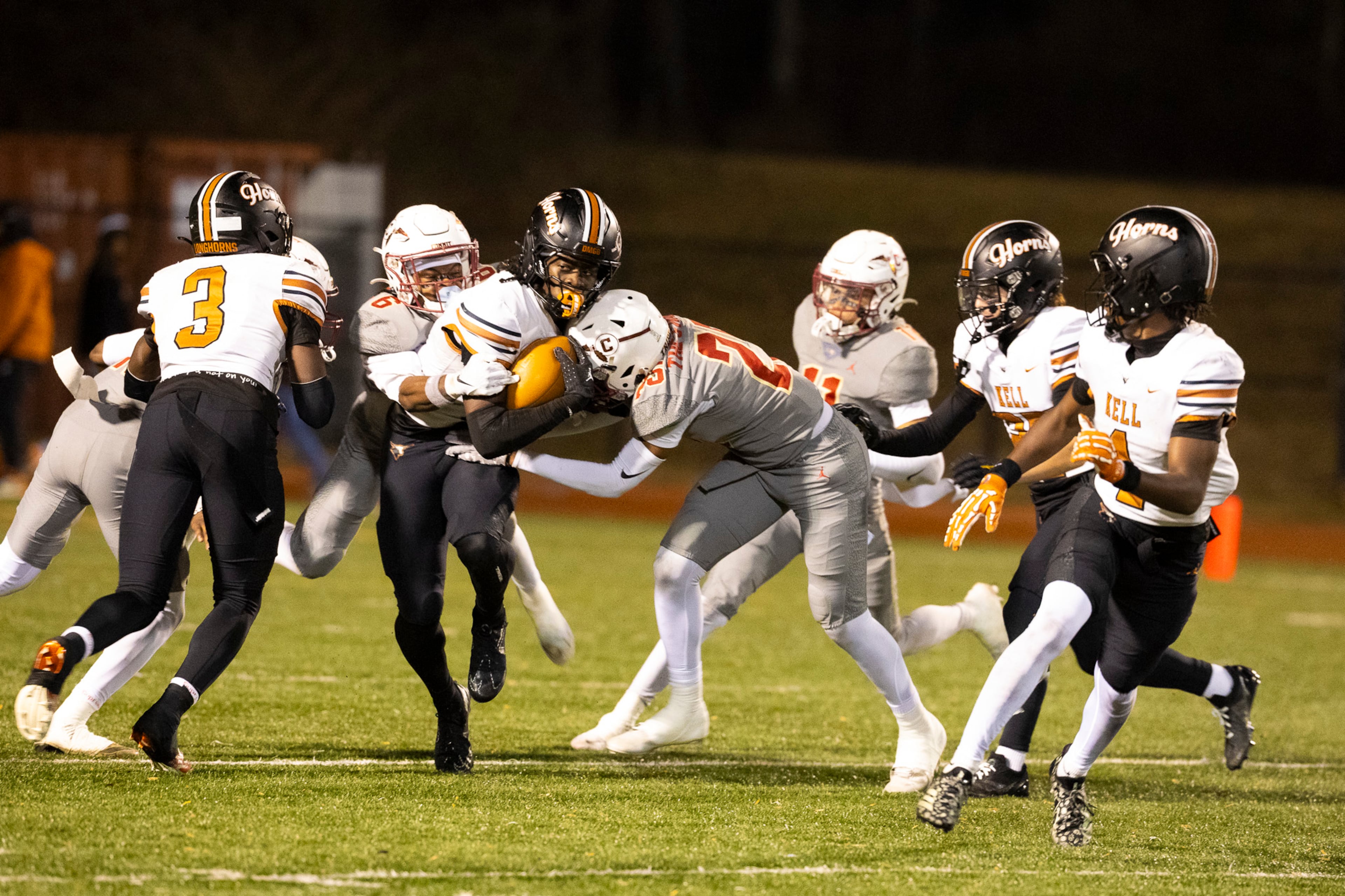 Kell quarterback Kaleb Narcisse (left) gets tackled during the Class 4A semifinal against Creekside on Friday, Dec. 5, 2025, at Creekside High School in Fairburn. (Oscar Guevara Saenz for the AJC)