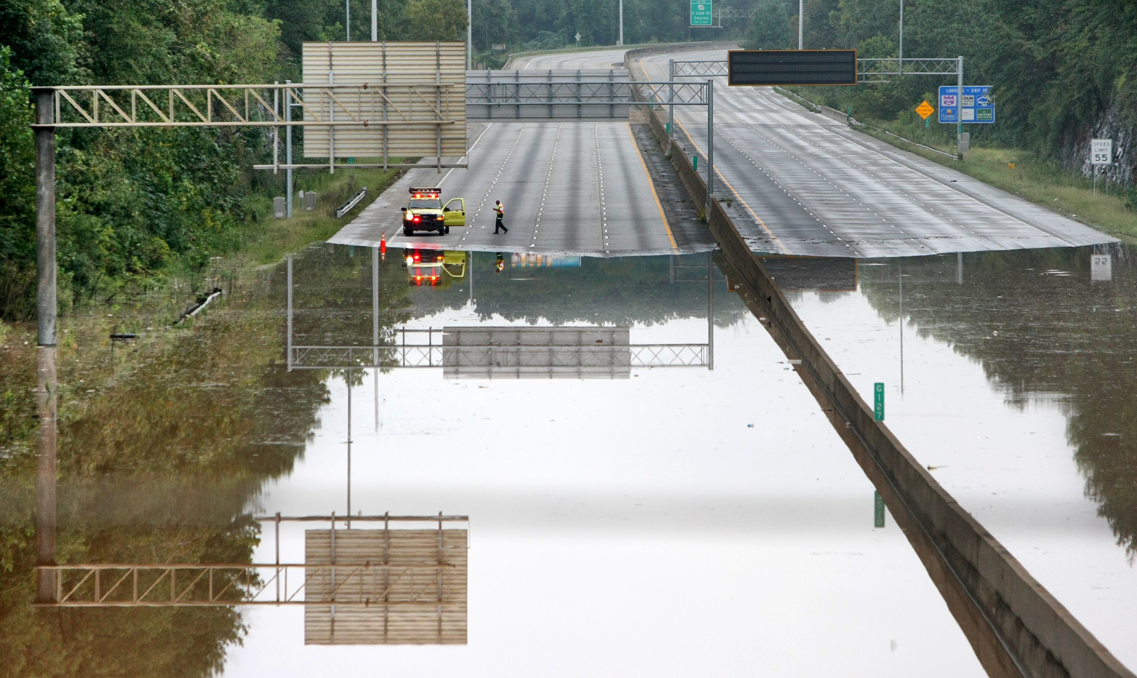 CORRECTION - (date) 090922 - Cobb County - A HERO driver makes an early morning assessment of the flooding I-285. The flooding continued Tuesday September 22, 2009 in the Atlanta metro area as I-285 at the Bolton Road overpass - north by several hundred yards was flooded over both sides of the interstate. Georgia Department of Transportation crews closed 11 bridges and a number of state-controlled roads and highways after Monday's flooding. DOT officials recommended that commuters who didn't need to travel remain home. "If someone is in an area that is experiencing flooding over the past few days, it may be a challenge to commute," spokeswoman Crystal Paulk-Buchanan. "The challenge that people are going to have are county roads and city roads." Among state thoroughfares, I-285 northbound at Hollowell Parkway and southbound at Cobb Parkway in Cobb County remained closed, because water from the Chattahoochee River was cresting the bridges. Flooding on Sweetwater Creek closed the I-20 eastbound lane between Lee and Thornton roads. The bridge will remain closed until the water recedes, and detours are in place. DOT also closed I-575 just at Highway 92 near the Cobb-Cherokee county line for flooding. DOT officials expect to open the three closed road sometime Tuesday, but Paulk-Buchanan said, in particular, bridges will remain closed so long as water is touching the underside of the bridges. John Spink, jspink@ajc.com