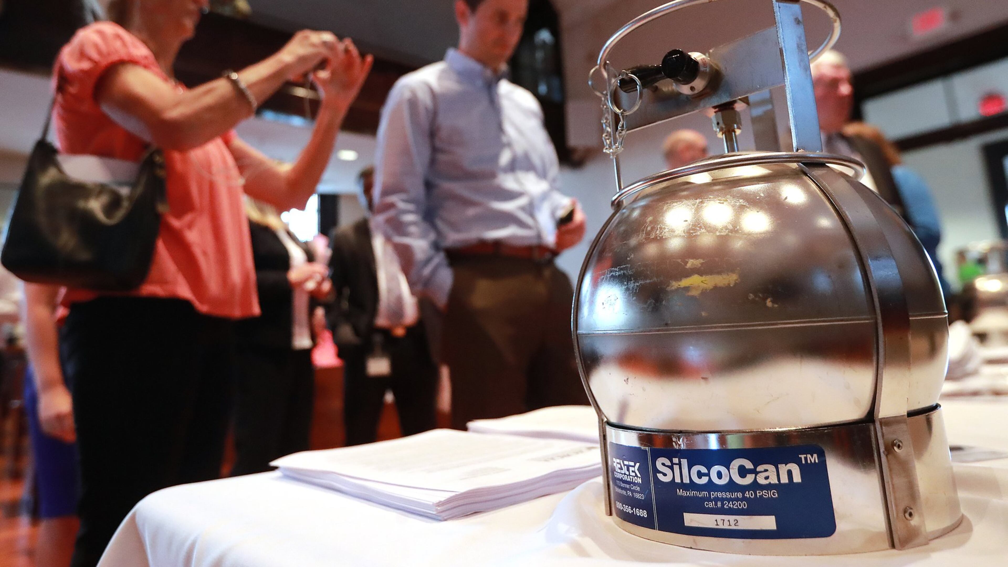 Residents attending a presentation Aug. 20 by federal and state environmental regulators look over a Summa canister used to collect air samples. The town hall in Covington was held amid growing fears over ethylene oxide gas emitted by the nearby Becton Dickinson plant.