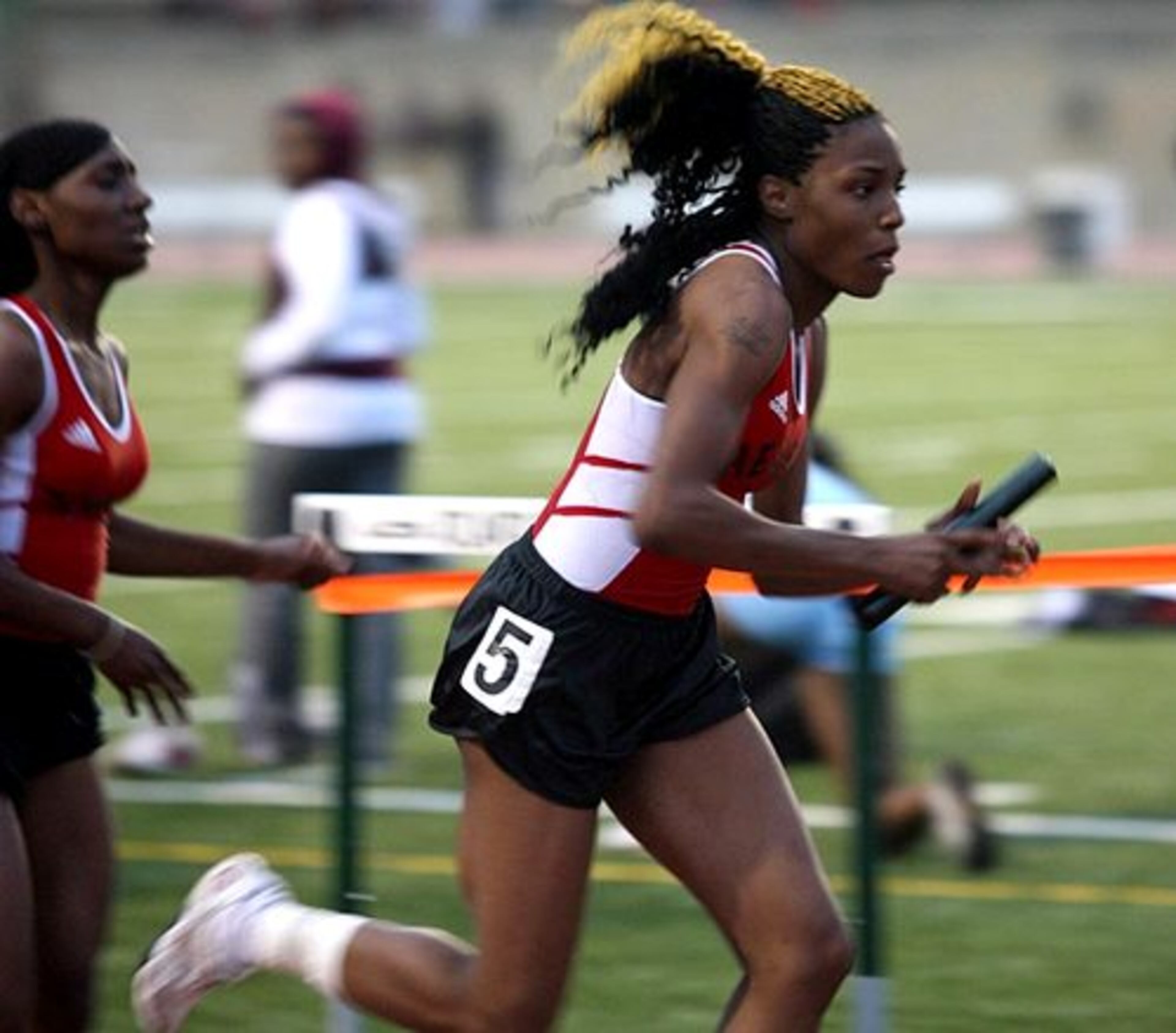 Therrell's Brittany Long (right) takes the baton from teammate Jawanda King (left) in the Girls' 4x1 Meter relay.