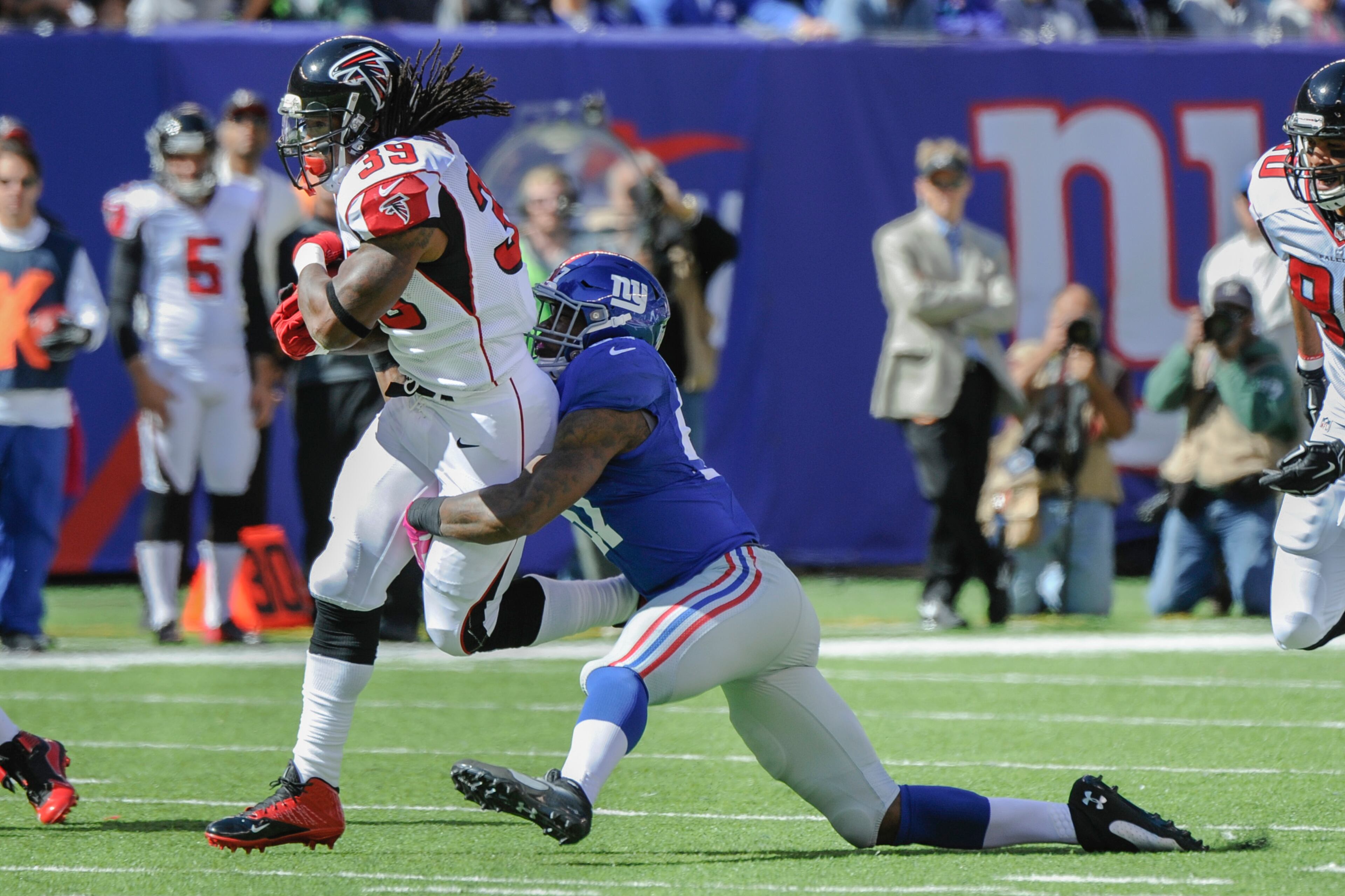Atlanta Falcons running back Steven Jackson, left, runs with the ball as New York Giants outside linebacker Jacquian Williams applies the tackle during the first half of an NFL football game, Sunday, Oct. 5, 2014, in East Rutherford, N.J. (AP Photo/Bill Kostroun)