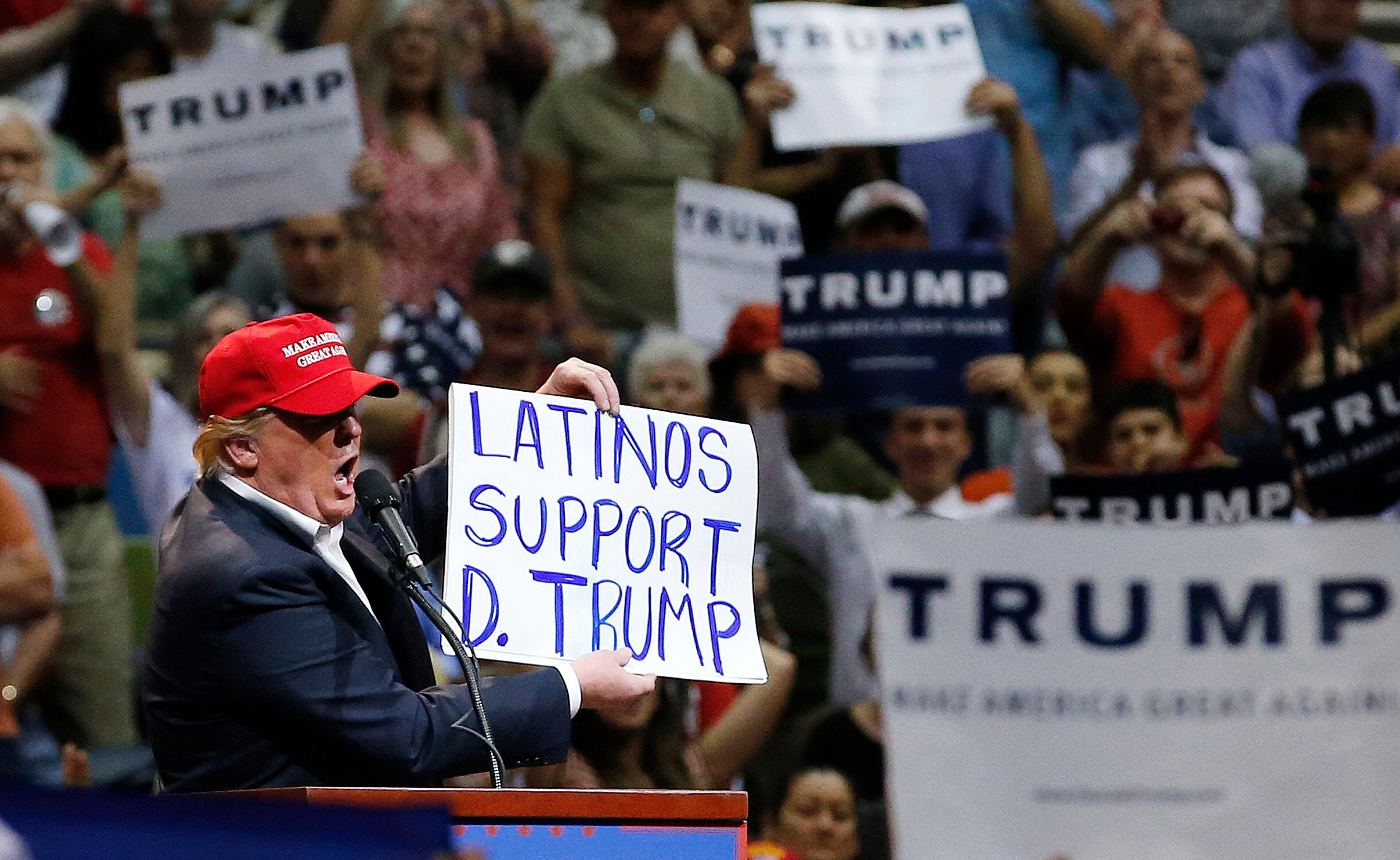 Republican presidential candidate Donald Trump holds up a sign from a supporter during a campaign rally Saturday, March 19, 2016, in Tucson, Ariz. (AP Photo/Ross D. Franklin)
