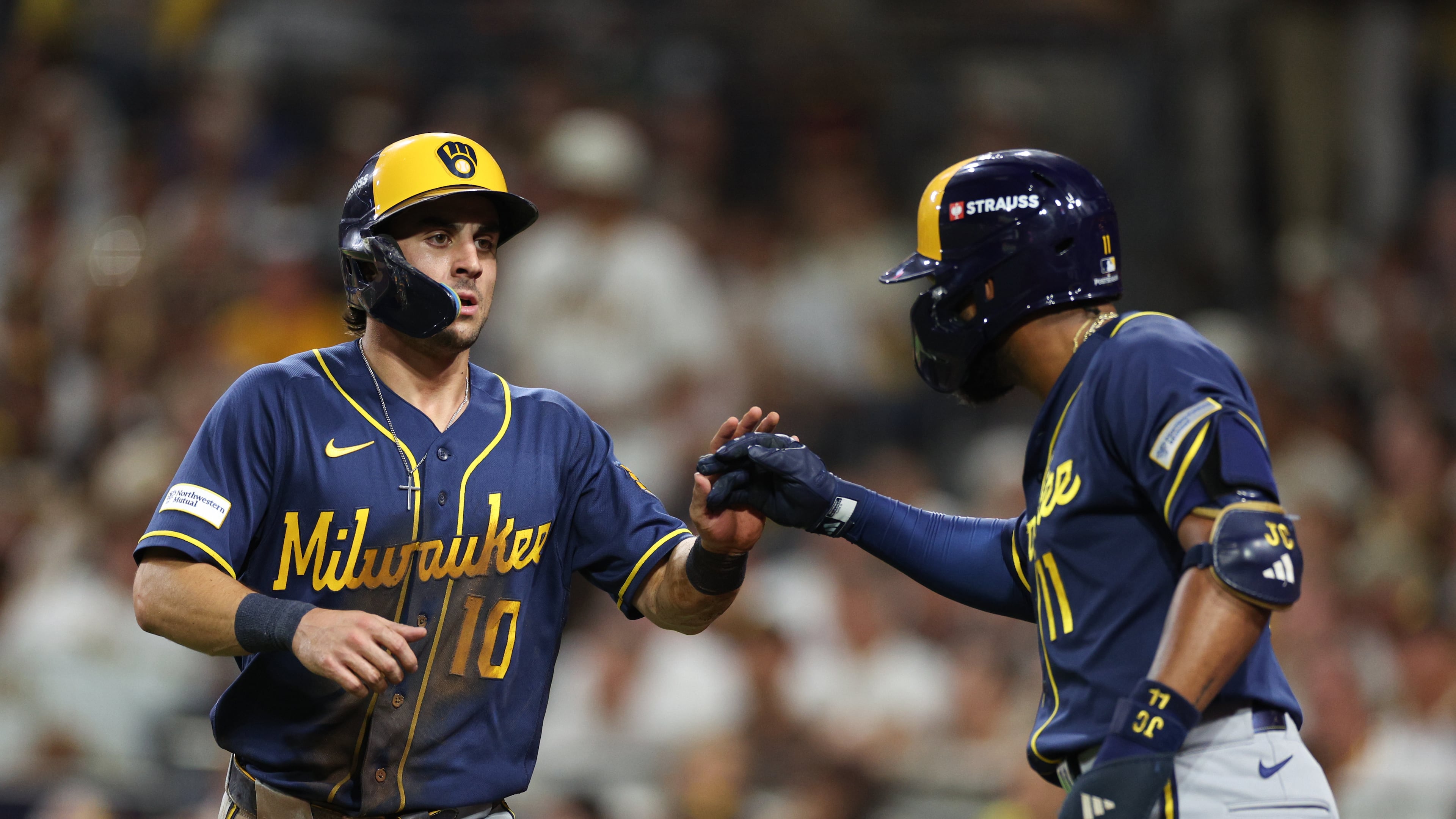 Milwaukee Brewers' Sal Frelick (10) is congratulated by Jackson Chourio after scoring on a single by Garrett Mitchell during the third inning in Game 4 of baseball's National League Division Series against the San Diego Padres Wednesday, Oct. 7, 2026, in San Diego. (AP Photo/Derrick Tuskan)