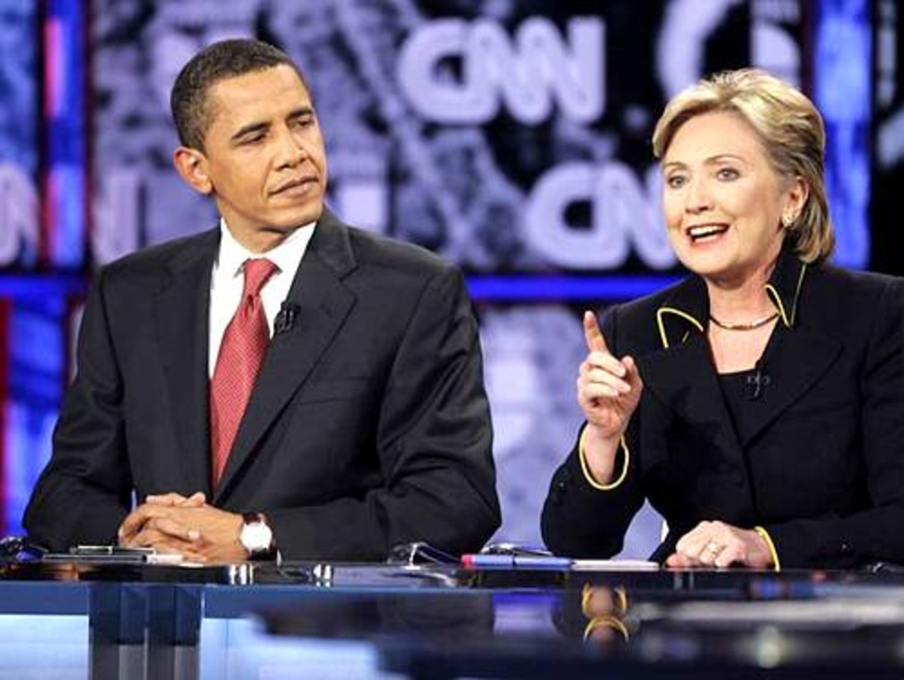 Sen. Barack Obama looks on as Sen. Hillary Rodham Clinton delivers her opening remarks before the Democratic presidential debate.
