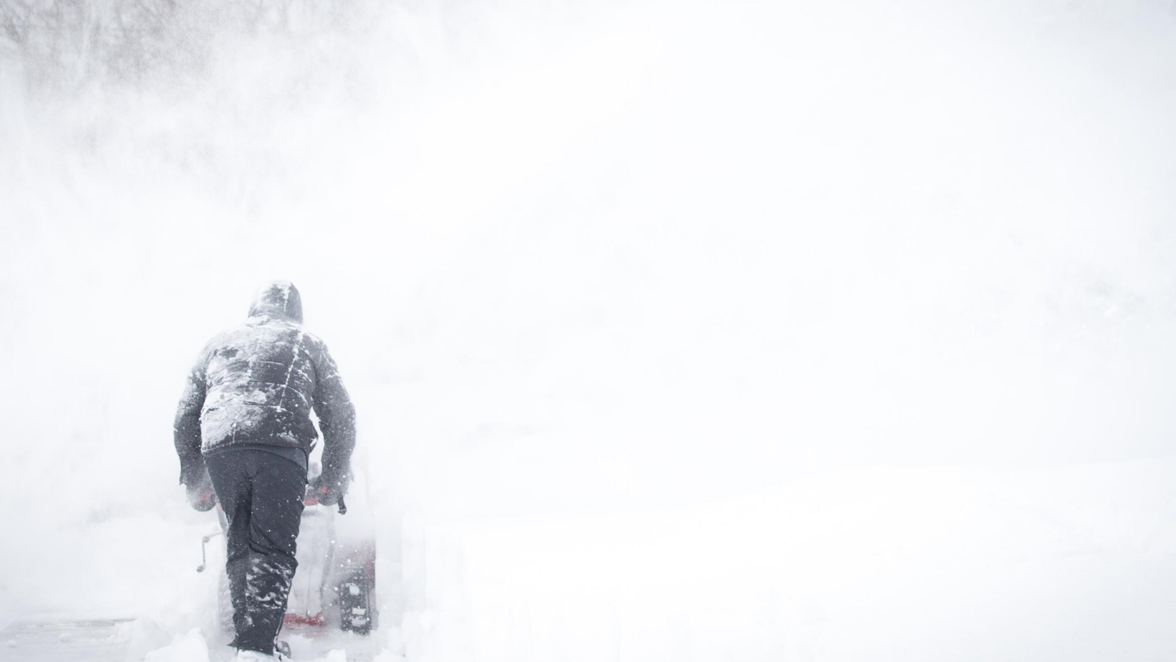 FILE PHOTO: A man uses his snowblower to clear his driveway and the road following a major snow storm .