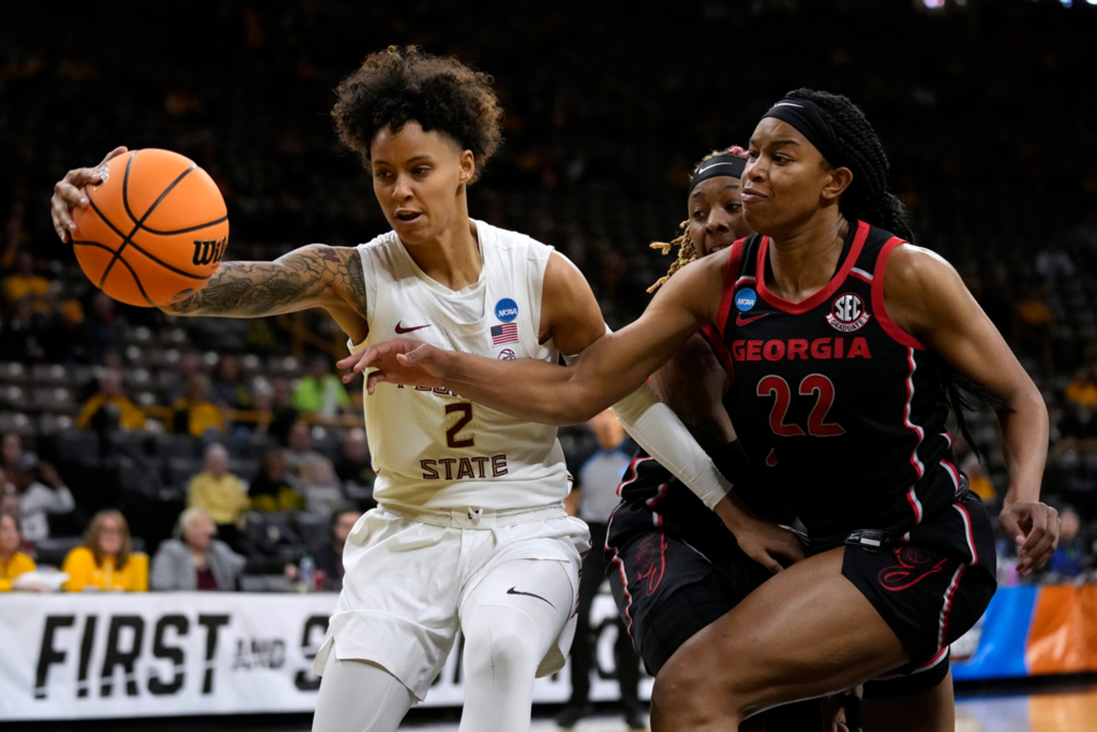 Florida State guard Brianna Turnage (2) fights for a loose ball with Georgia forward Malury Bates (22) in the first half of a first-round college basketball game in the NCAA Tournament, Friday, March 17, 2023, in Iowa City, Iowa. (AP Photo/Charlie Neibergall)