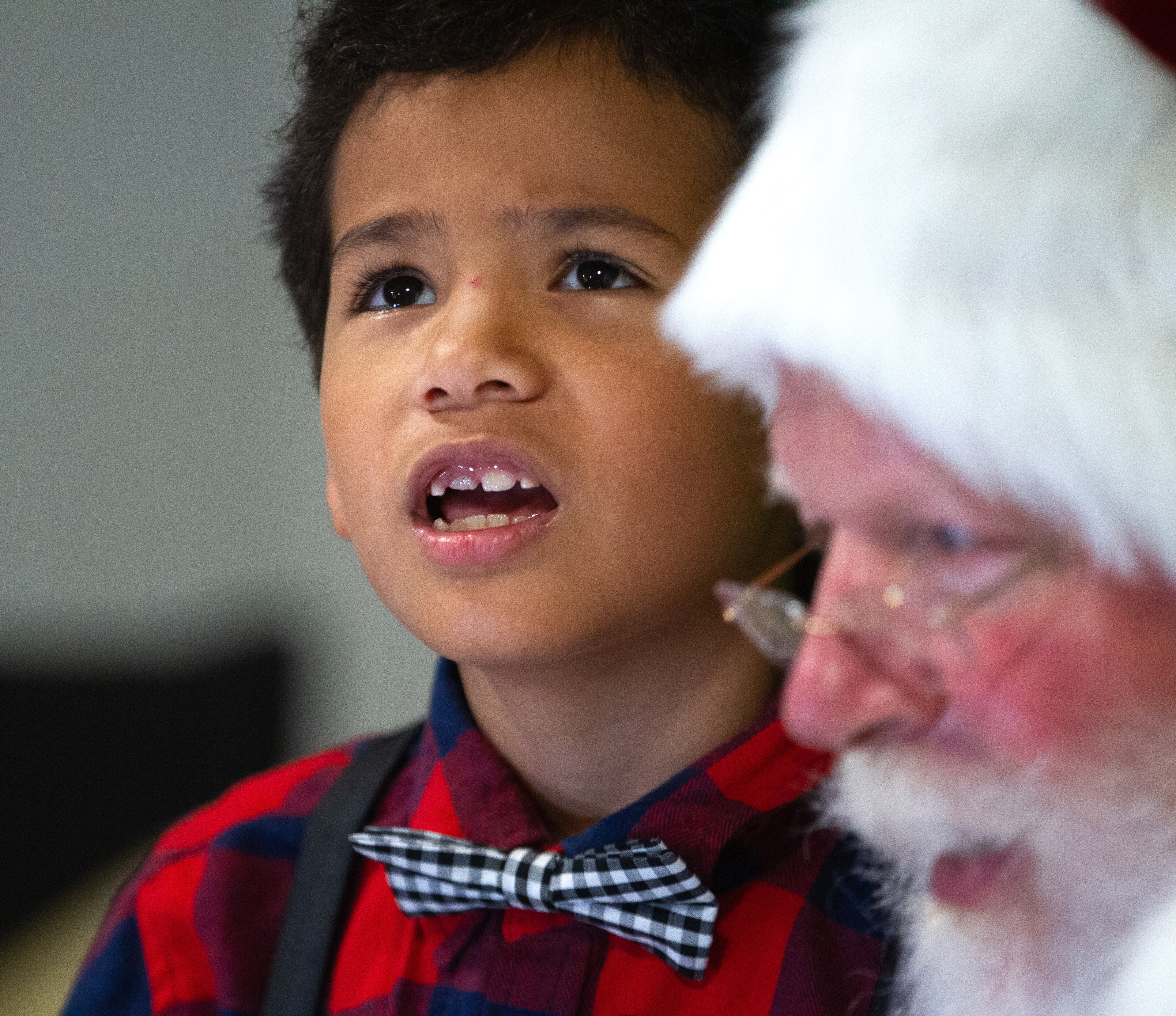 Carlos Sorto, 8, thinks about what he wants to ask Santa for Christmas during the Doraville sesquicentennial grand finale celebration at the Forest Fleming Arena on Saturday, December 11, 2021. STEVE SCHAEFER FOR THE ATLANTA JOURNAL-CONSTITUTION