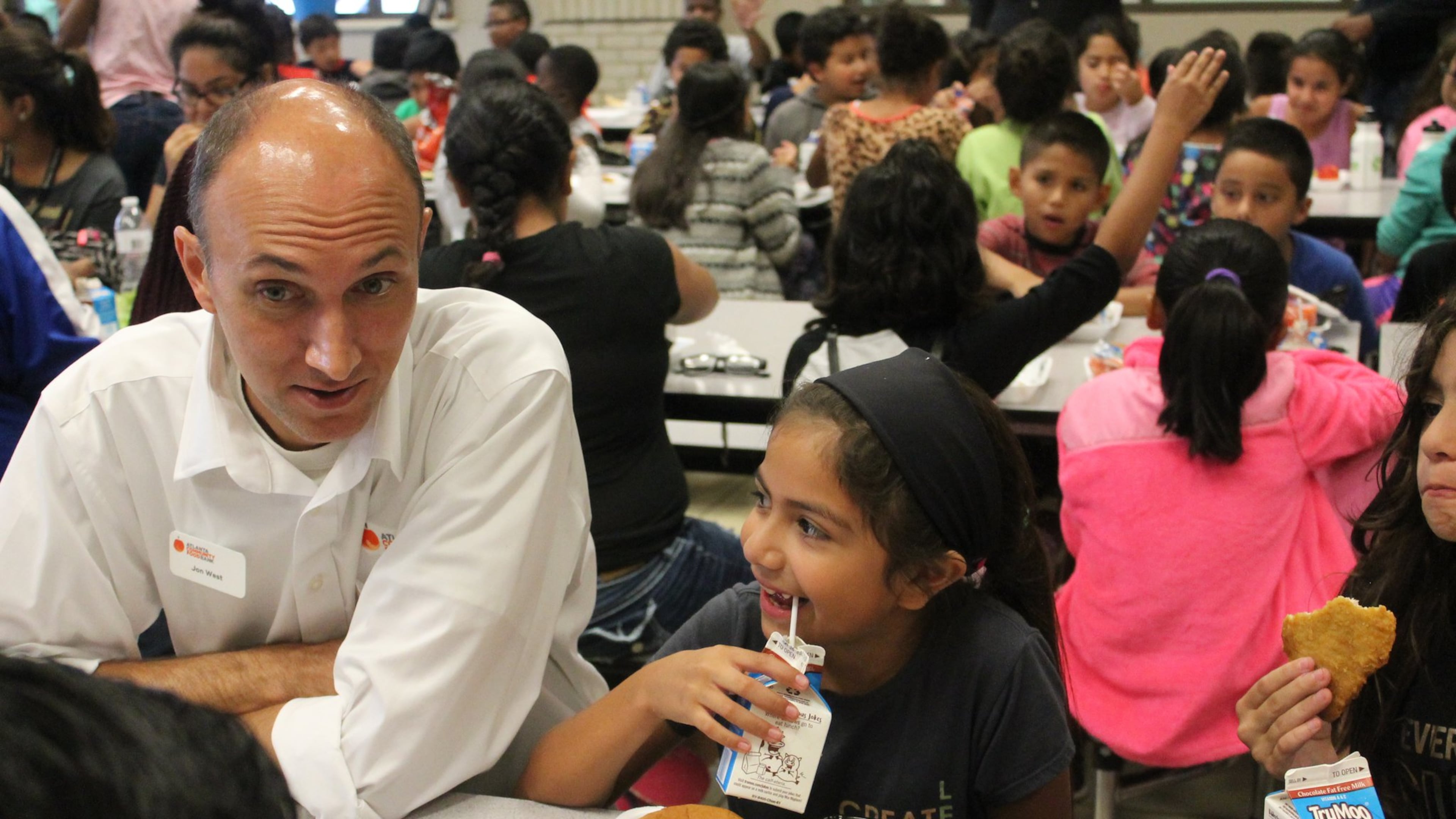 Atlanta Community Food Bank Vice President of Programs Jon West talks with children at a Hall County school during one of the organization’s events promoting summer meals. CONTRIBUTED