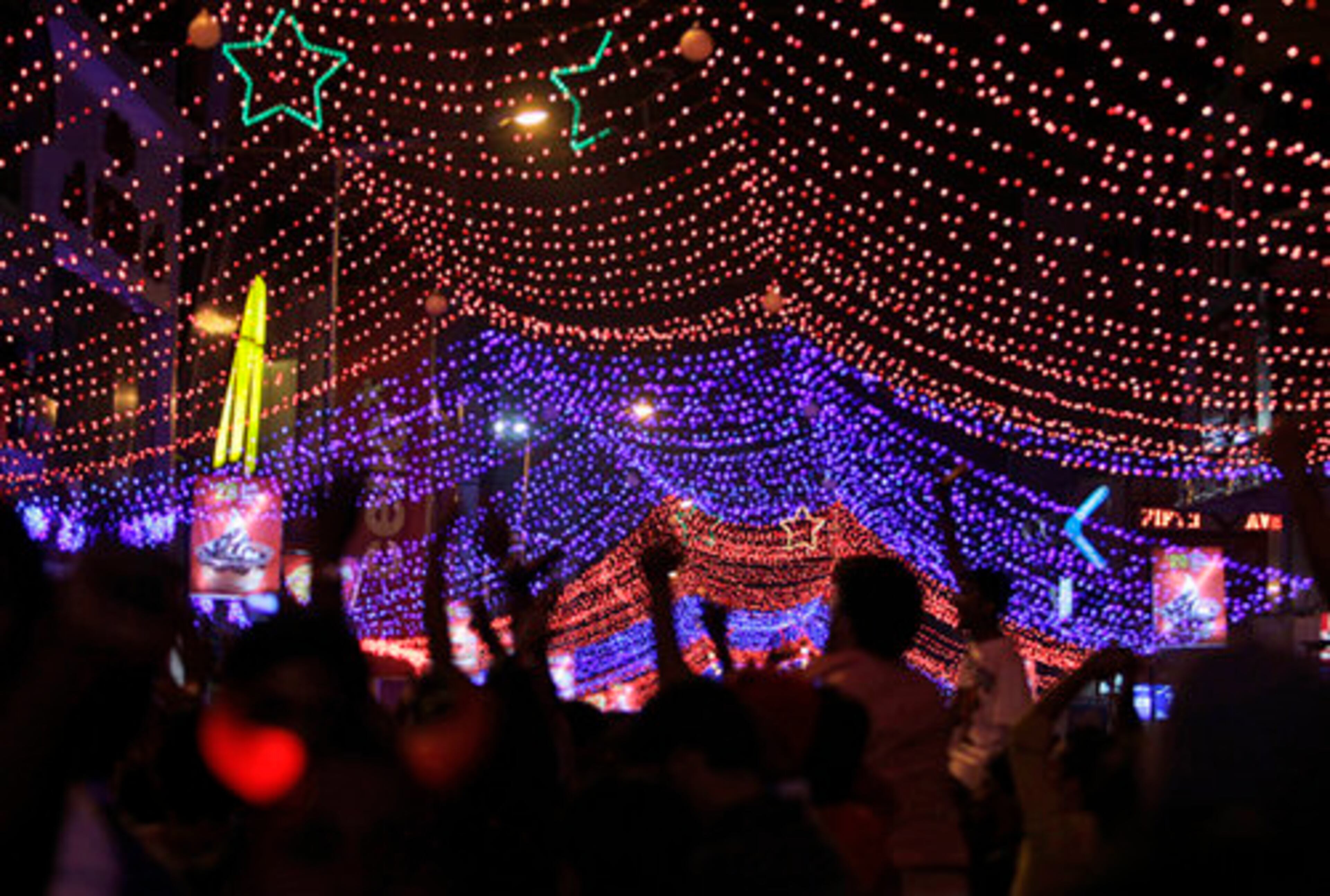 People dance on a decorated street in Bangalore, India, to celebrate New Year's.
