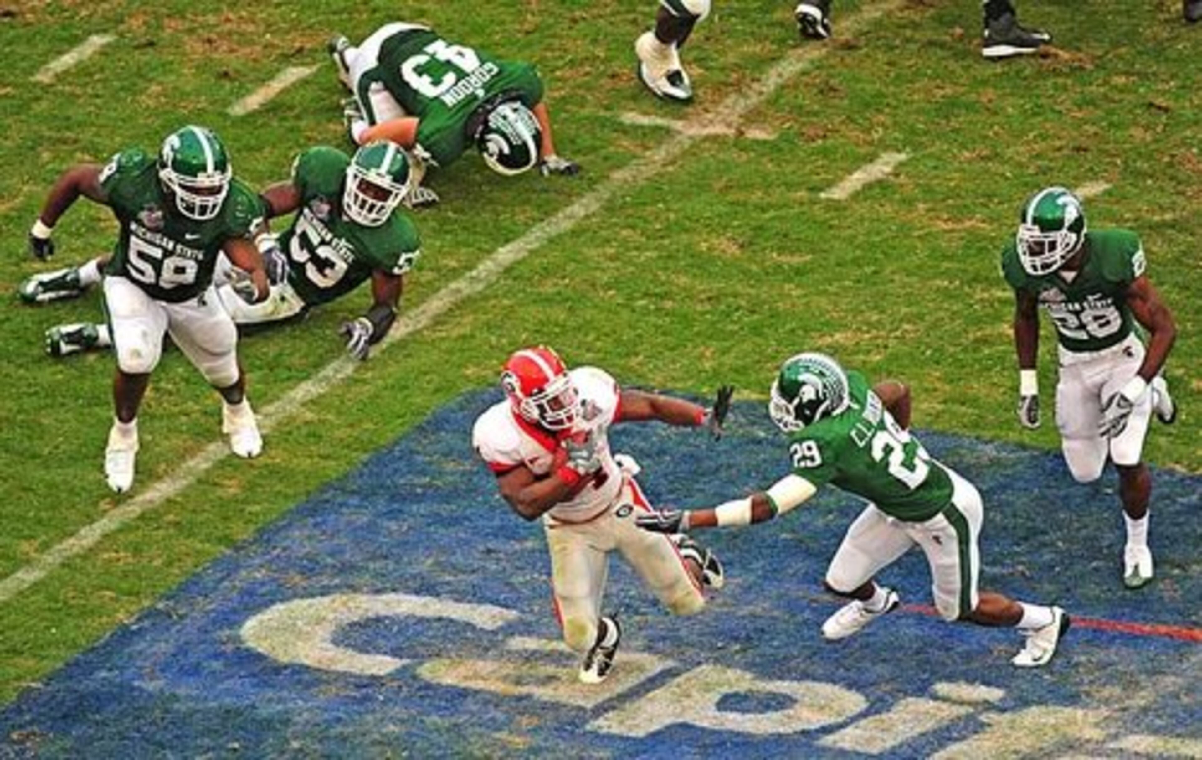 Georgia running back Knowshon Moreno (24) evades a large cluster of Michigan State defenders as he rushed for 68 yards and caught one touchdown pass in the victory.