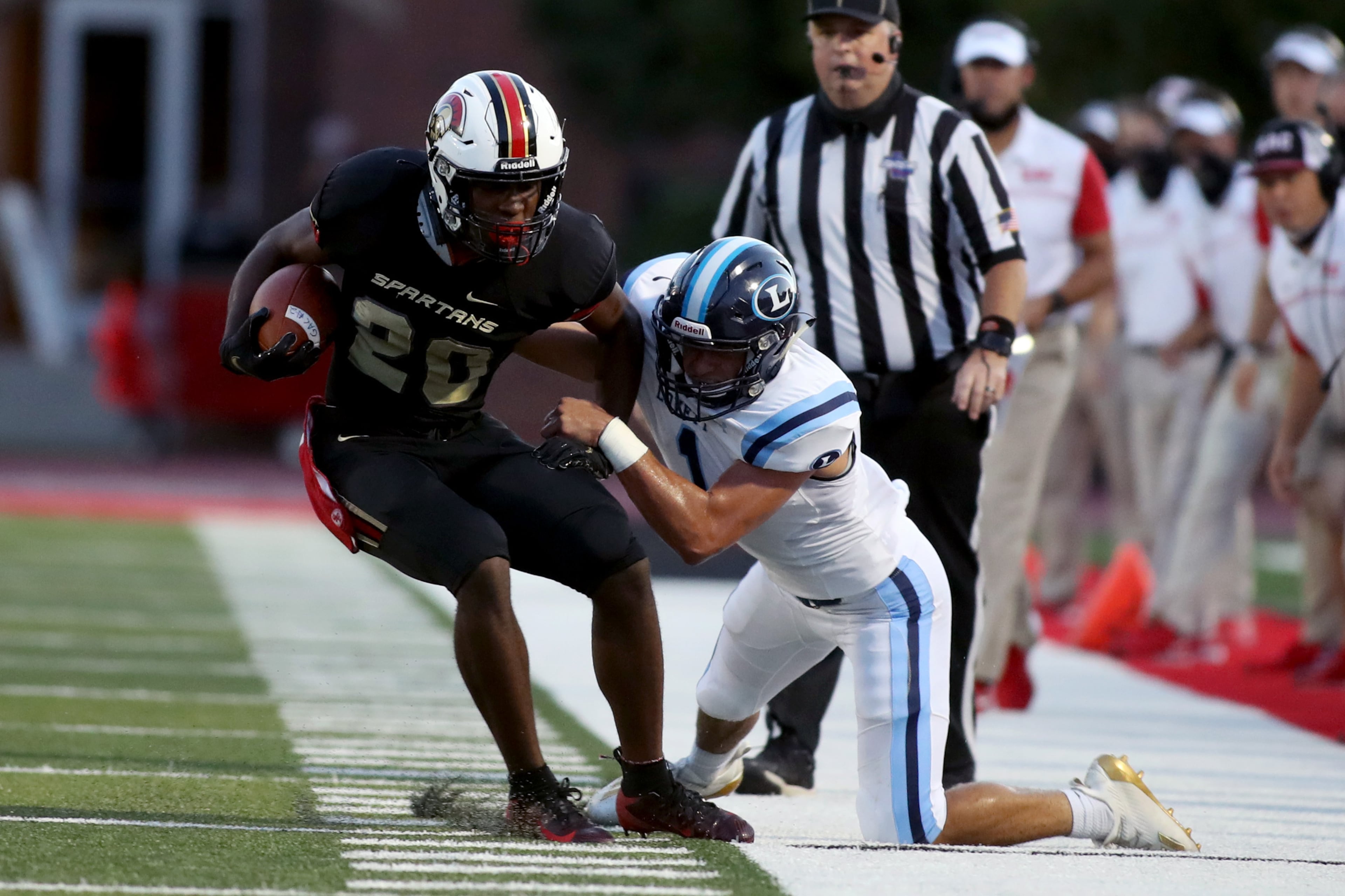 GAC running back Gannon Hearst (20) runs against Lovett defensive back Collin Goldberg (1) in the first half of Friday's game. (Jason Getz/Special to the AJC)