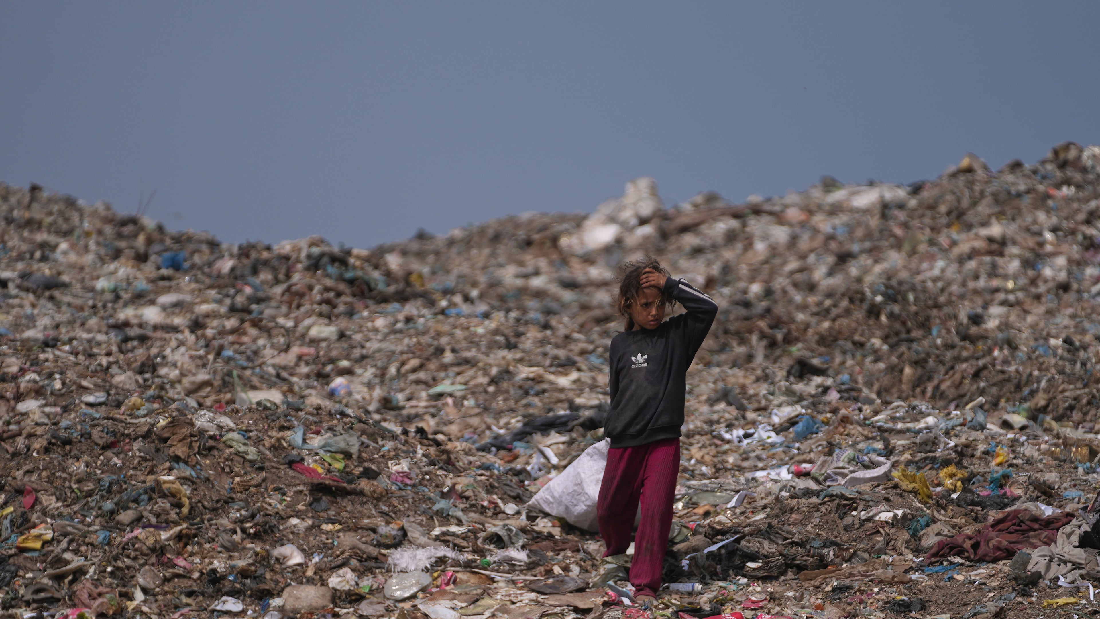 A Palestinian girl searchs for reusable items at a landfill in Deir al-Balah, in the central Gaza Strip, Thursday, July 23, 2026. (AP Photo/Abdel Kareem Hana)