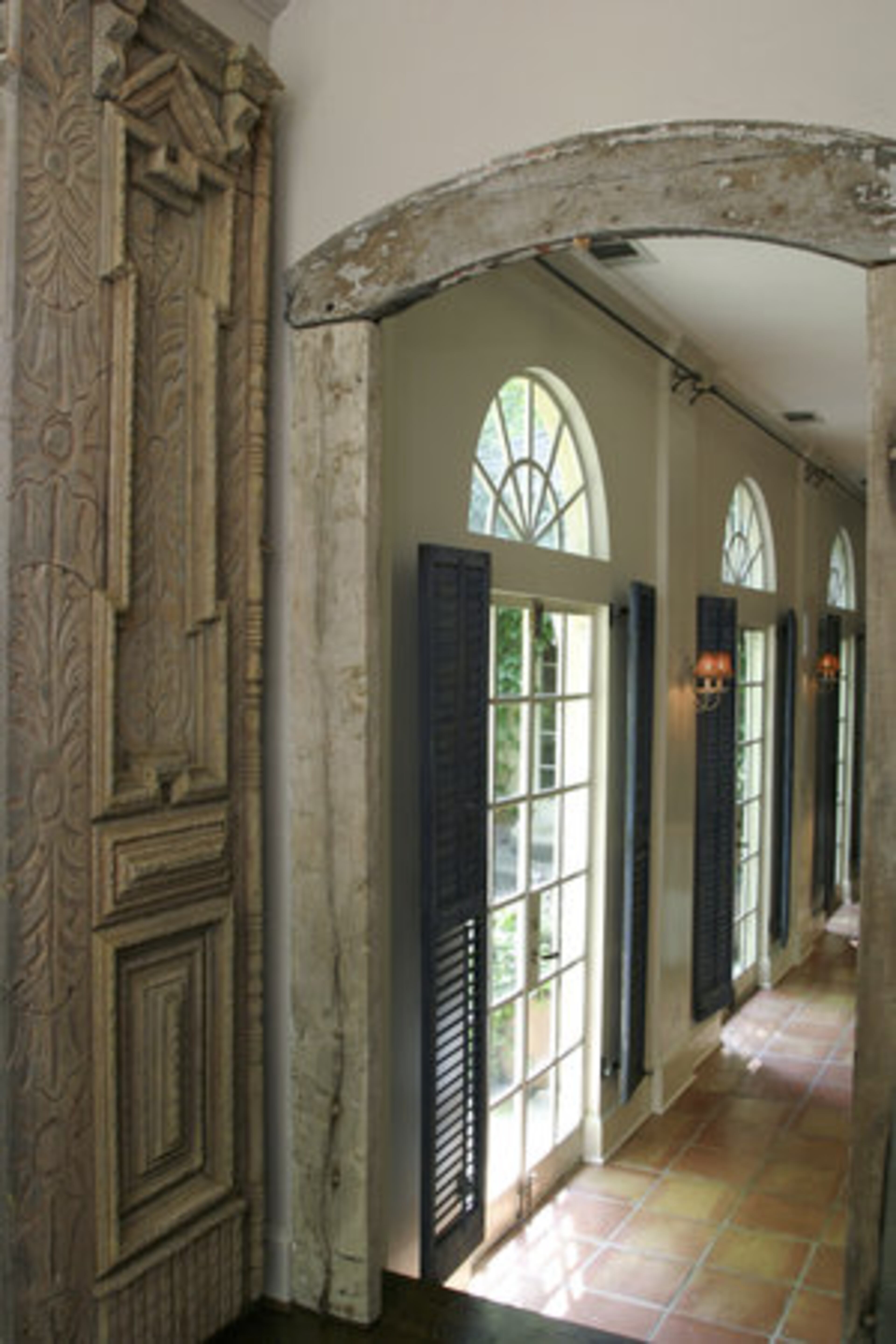 Two hefty doors sourced in Morocco frame the doorway to the home-office. "I tried to sell them twice, then I thought: Why am I selling these?" They butt a surround she sourced in France that trims the doorway between the foyer and living room.