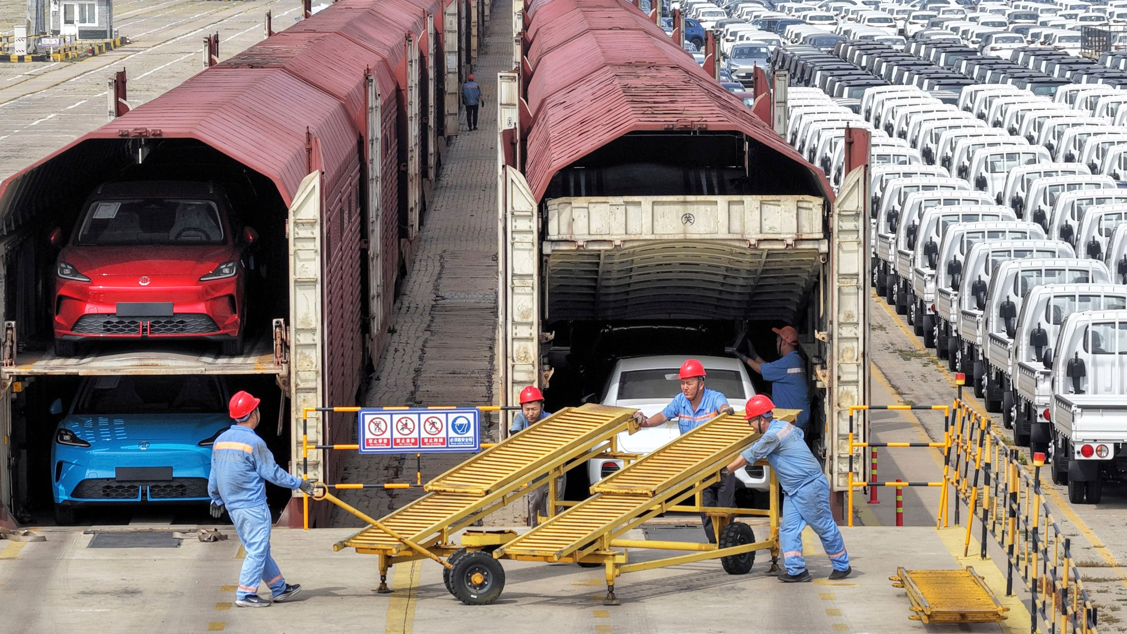 Workers prepare cars for shipment by rail in Yantai, eastern China's Shandong province, on June 20, 2026. (Chinatopix via AP)