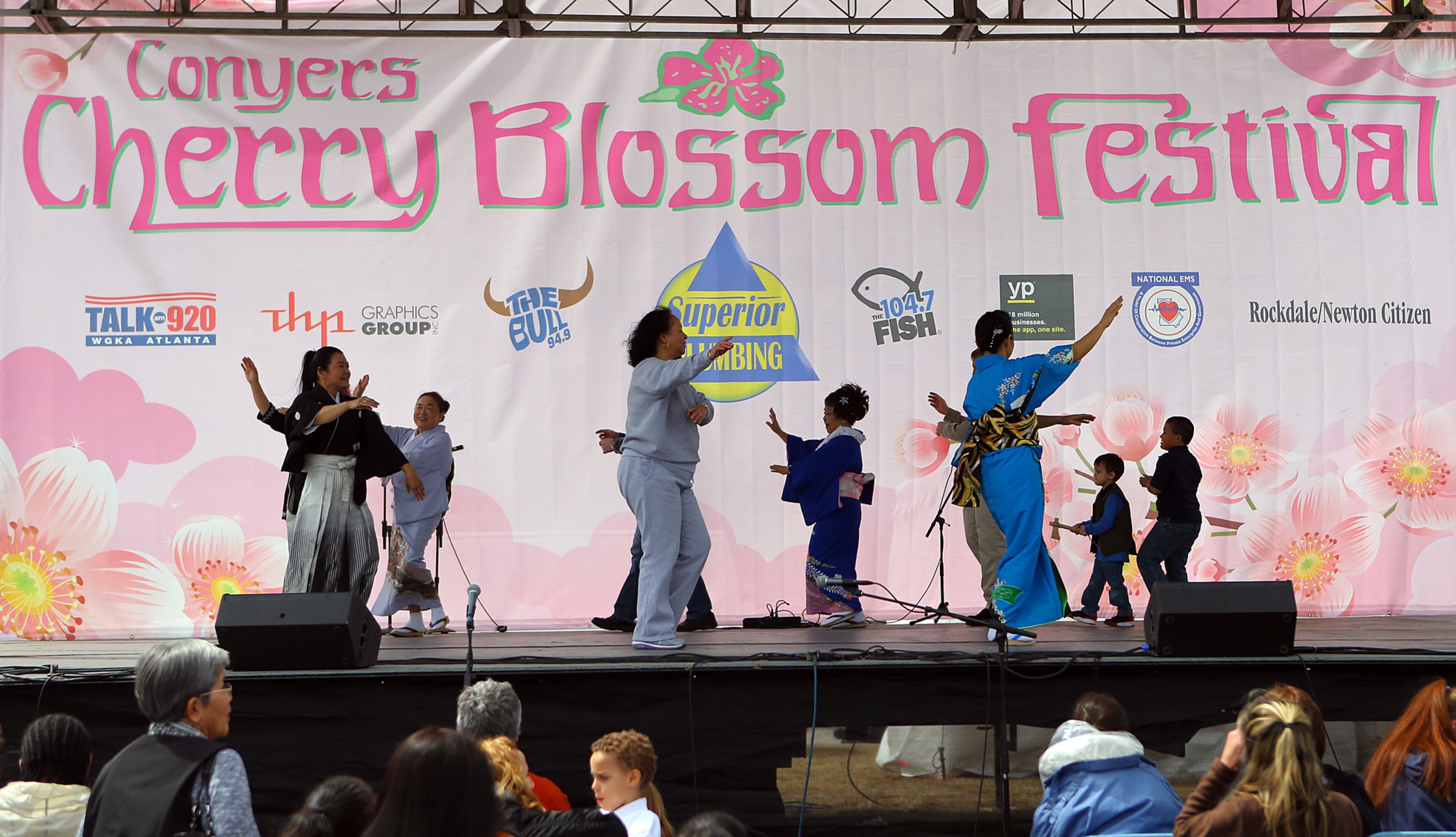 The Kinuyo Shinobu Kai dance group get members of the crowd up on stage to help perform a traditional Japanese Cherry Blossum folk dance at the 33rd Annual Conyers Cherry Blossom Festival on Sunday, March 23, 2014, in Conyers.