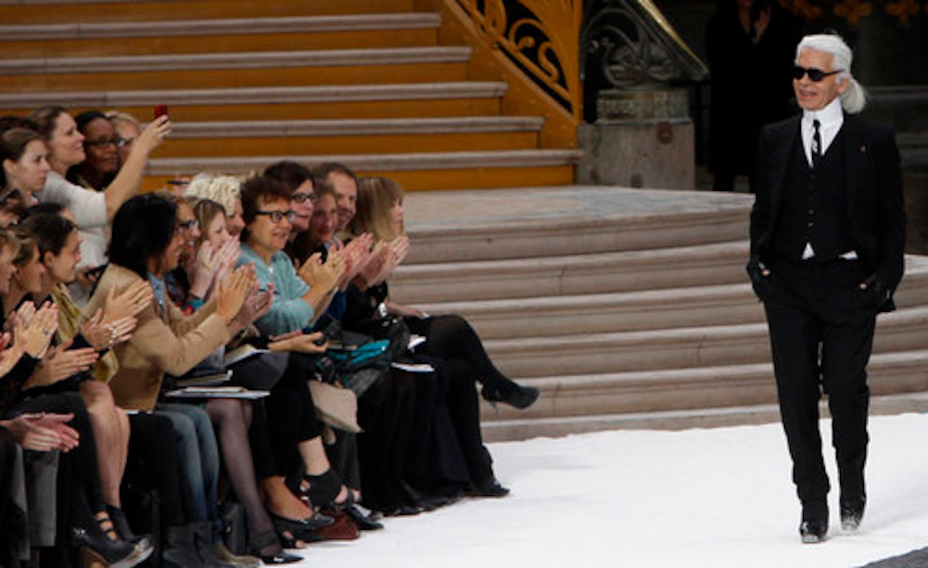 German fashion designer Karl Lagerfeld acknowledges applause at the end of his spring-summer 2011 ready to wear collection for Chanel, presented in Paris' Grand Palais museum.