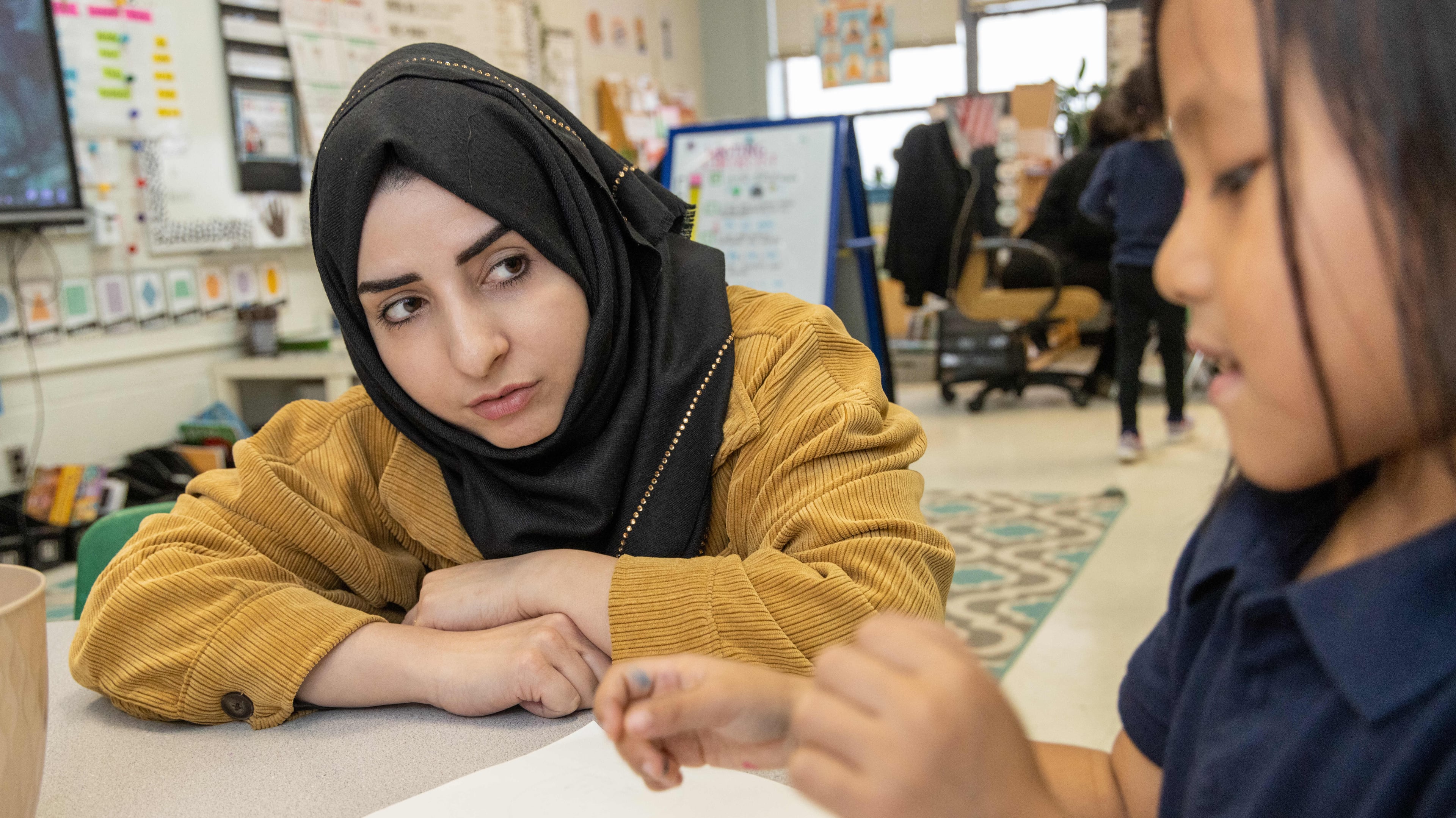 Shaikila Amiaq (left), a recent Afghan refugee who is studying to become a teacher, helps Ritu Gurung in Taylor Thomas' kindergarten class at the International Community School in Clarkston. PHIL SKINNER FOR THE ATLANTA JOURNAL-CONSTITUTION