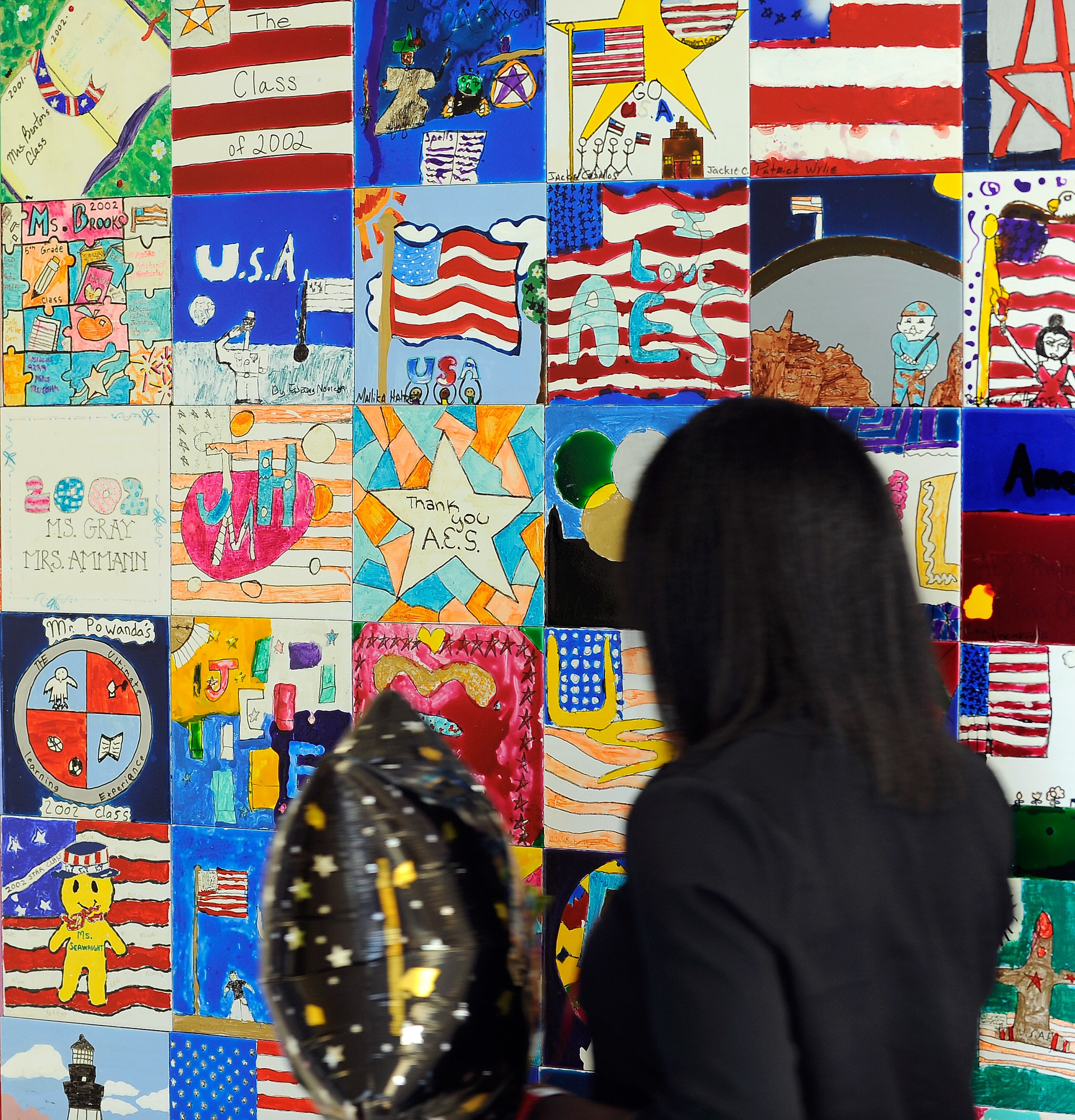 A family relative walks past colorful tiles decorating the main hallway commemorating a previous fifth grade service project at Alpharetta Elementary School, Friday, May 23, 2014, in Alpharetta, Ga. David Tulis / AJC Special