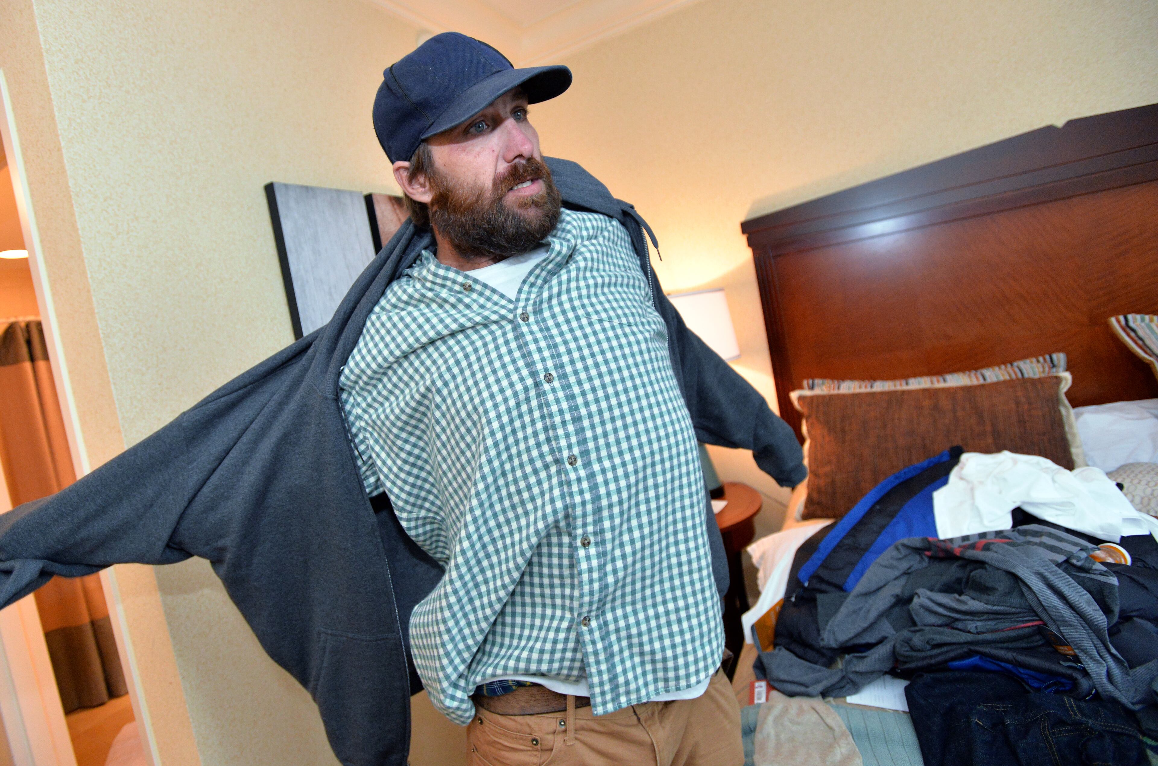 Joel Hartman, the homeless man now staying at the Omni Hotel at CNN Center, gets ready in his hotel room before he goes out to visit his "dungeon" on Saturday, November 23, 2013. Hartman's hotel room is among the rewards he's received for tracking down the owner of a wallet he found while digging through the trash for food. The wallet's owner was a guest at the Omni. When Hartman gave the wallet to Omni security guards, he didn't give them any information on how he could be reached. He simply went back out onto the streets. So Omni staffers went looking for him and put the word out that they considered him a hero. Hartman, who has been homeless since March, said he thought of only one thing when he found the stolen wallet, which contained a credit card: Giving it back.